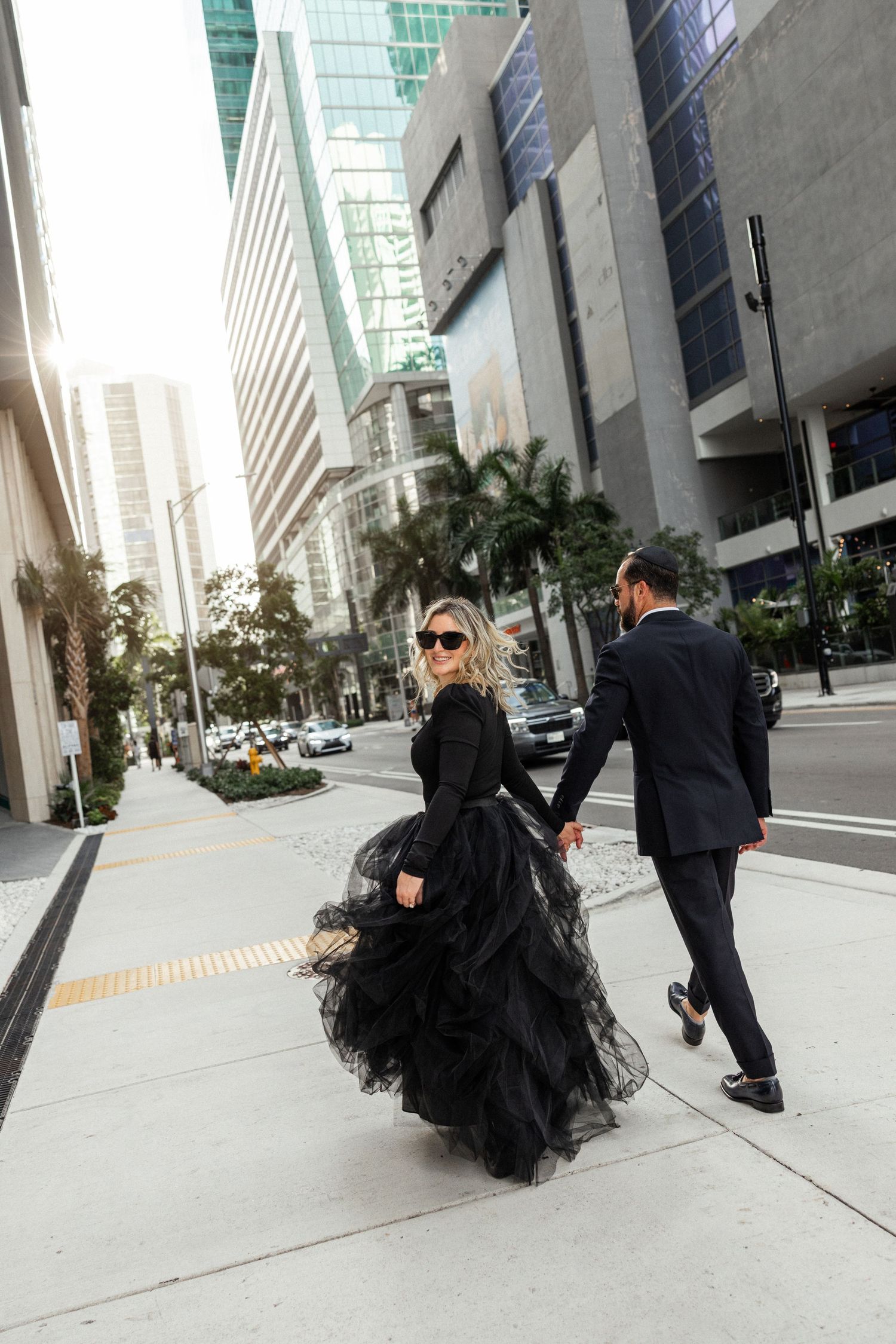 Urban photoshoot featuring dramatic black tulle dress against modern city buildings.