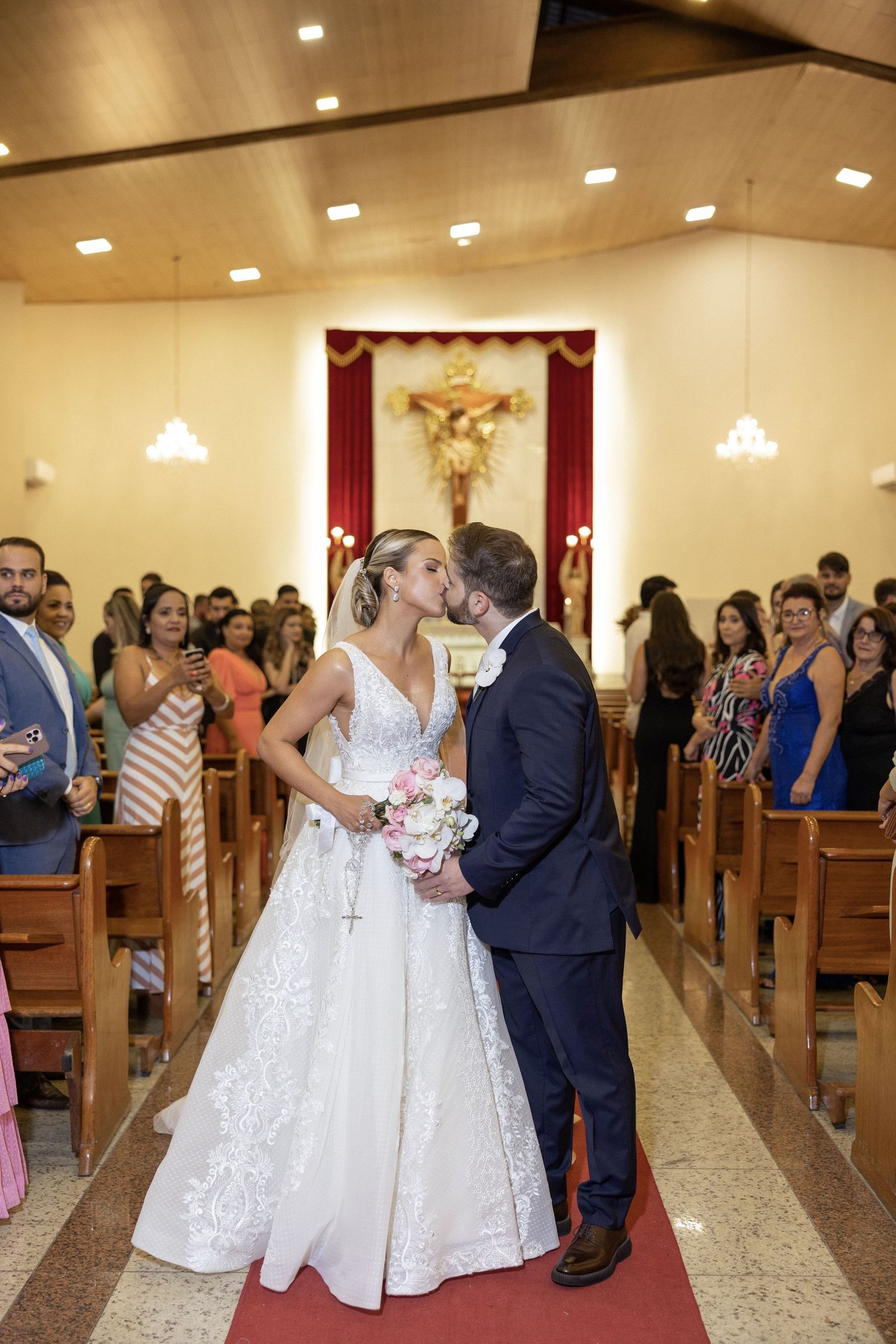 Wedding ceremony in a church with guests seated in pews.