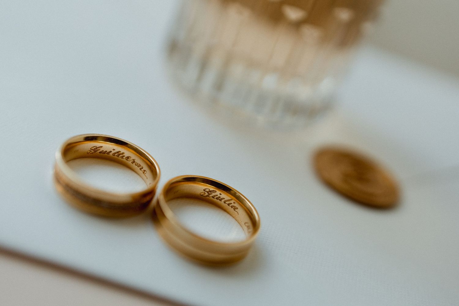 Close-up macro shots of golden wedding rings with shallow depth of field.