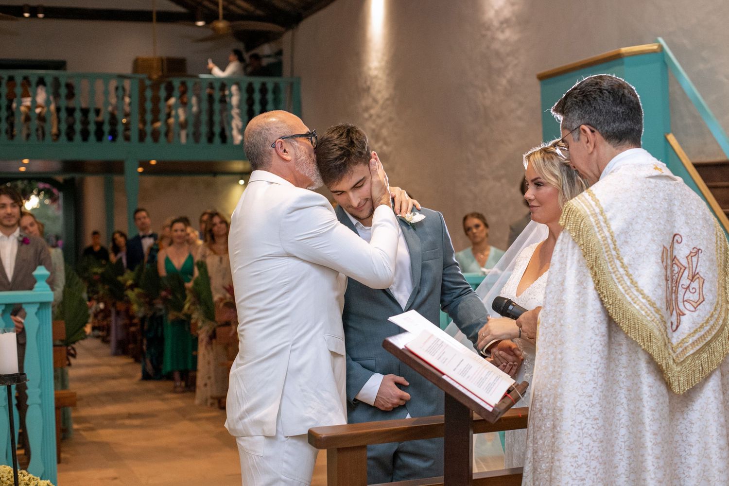 Wedding ceremony in an elegant venue with white and gold decor.