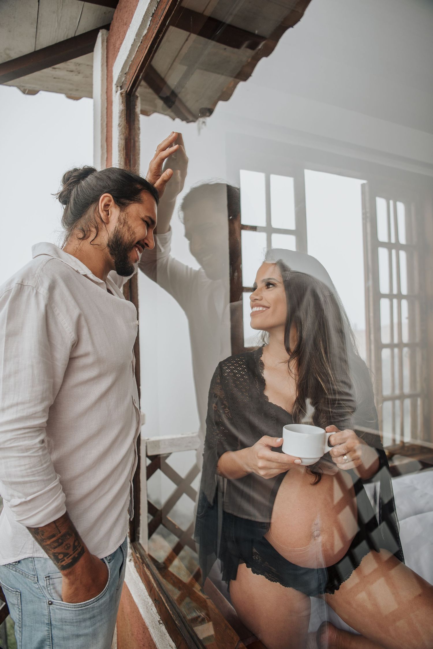 Romantic indoor photoshoot with rustic window light and casual attire.