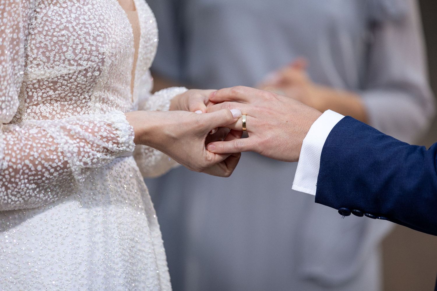 Close-up of wedding ring exchange during ceremony.