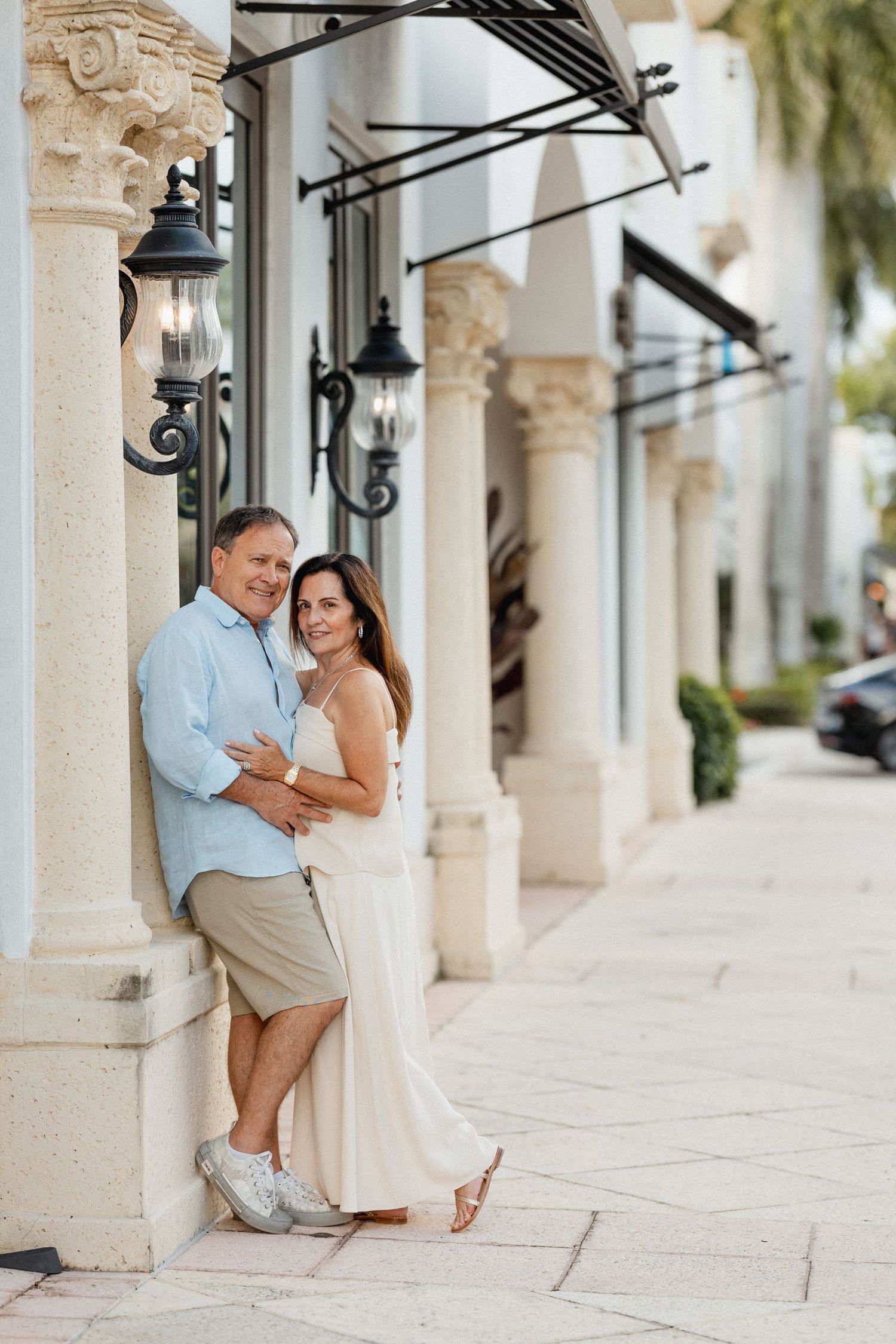 Romantic engagement photos under stone archways with decorative iron lanterns.