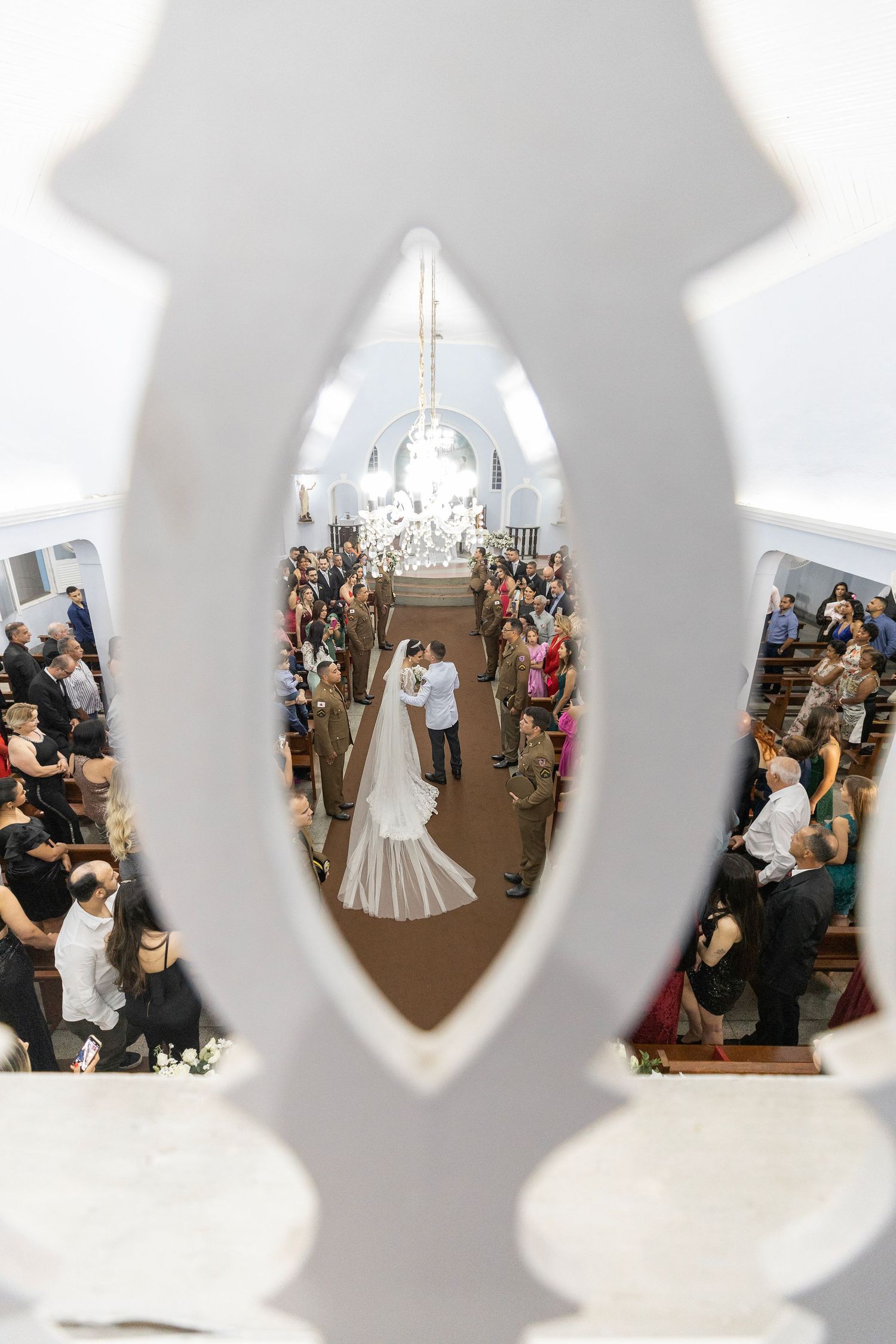 Creative wedding photography through decorative window frames in a church setting.