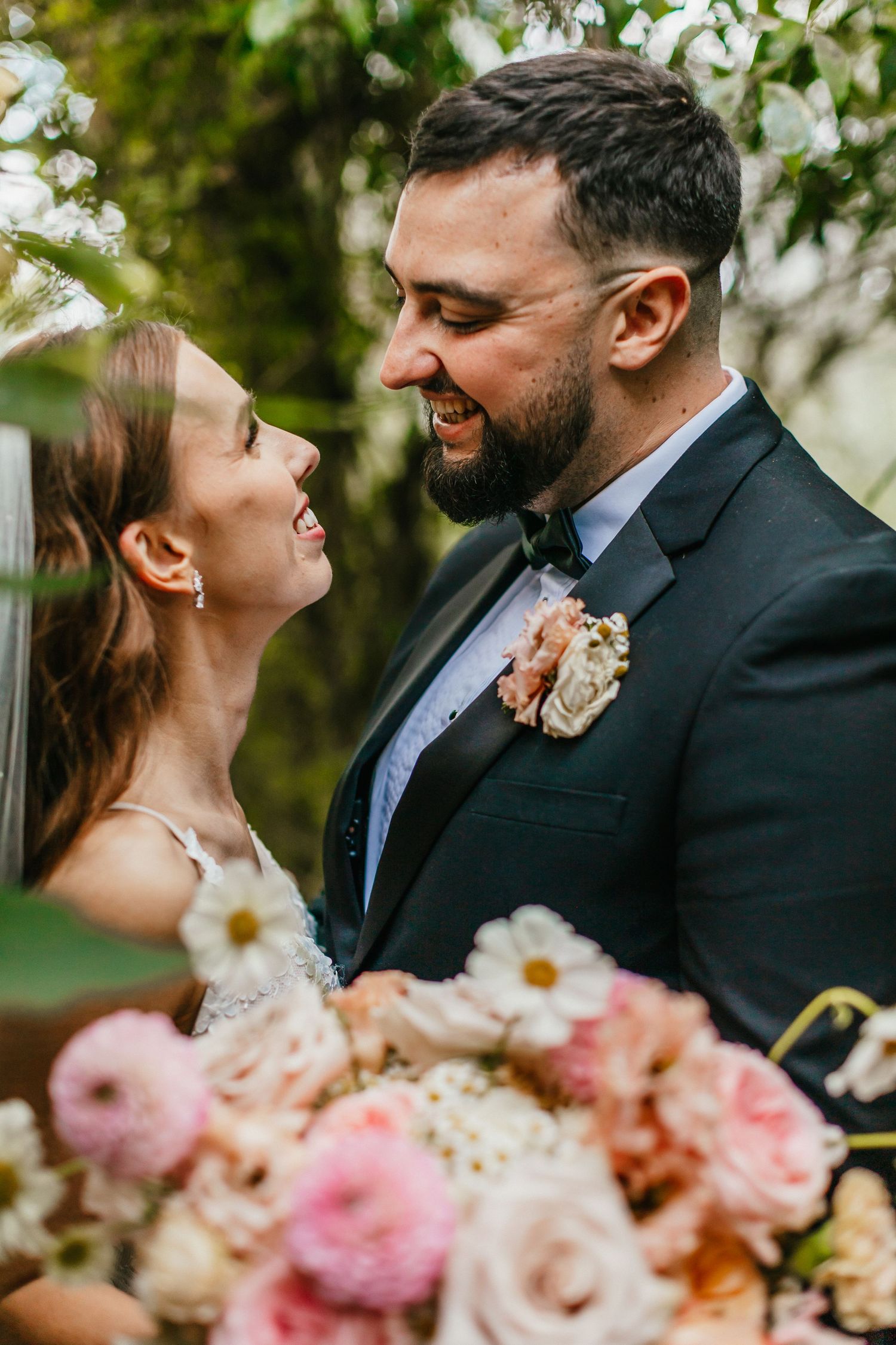 Romantic wedding portrait with pink and white floral bouquet in garden setting.