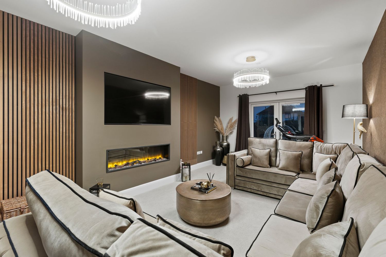 Modern living room with wood accent wall, fireplace, and circular pendant lights.