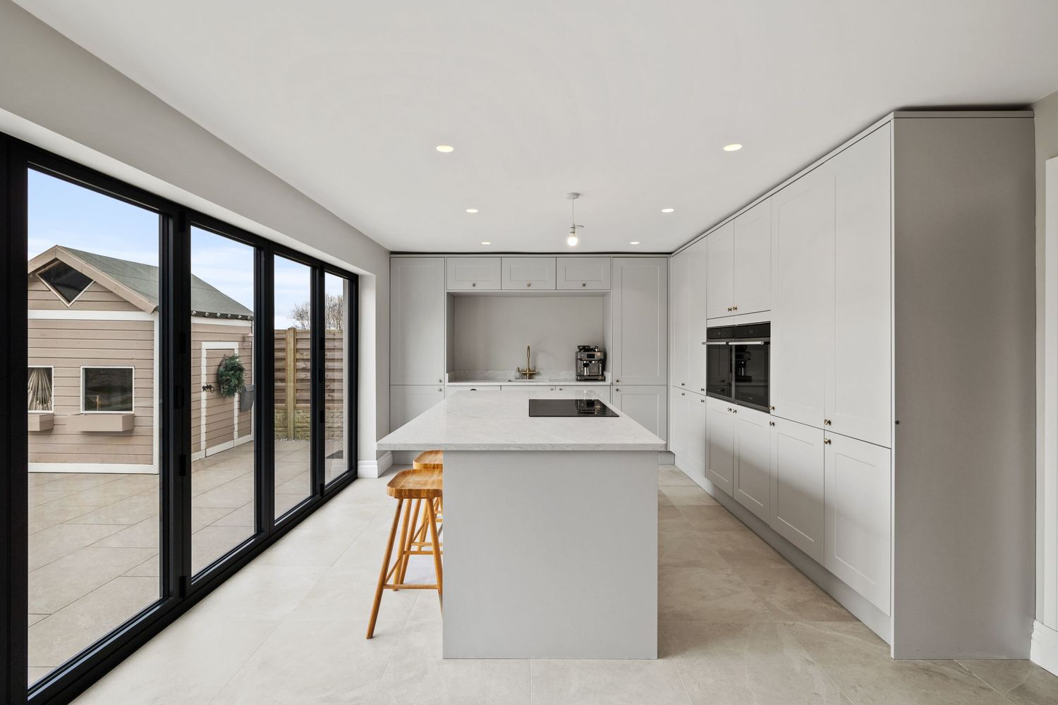 Sleek contemporary kitchen featuring sliding glass doors and a large center island with minimalist design.