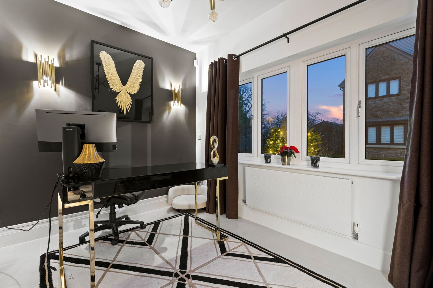 Contemporary home office with black accent wall, gold artwork, and modern furniture.