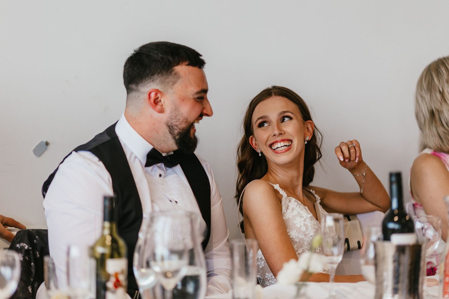 A candid moment of laughter shared during a wedding reception dinner.