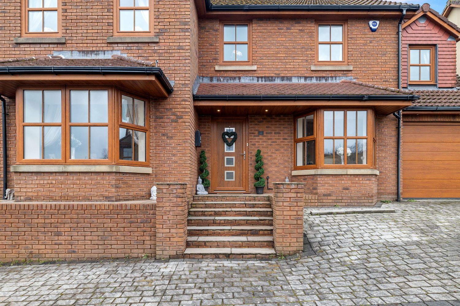 Modern red brick townhouse entrance with stone steps and bay windows.