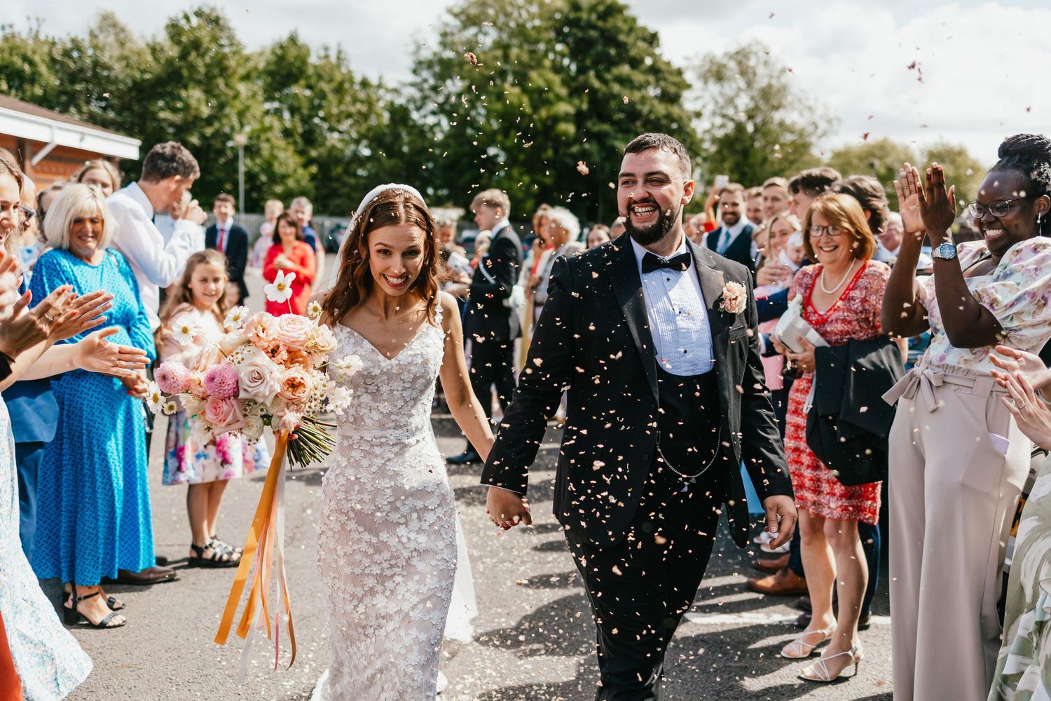 Celebratory moment with confetti shower as couple exits wedding ceremony.