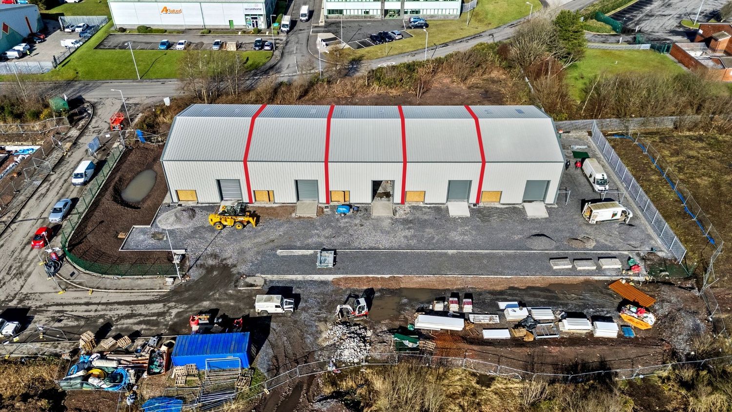 Aerial view of industrial storage units with vehicles and equipment in the yard.