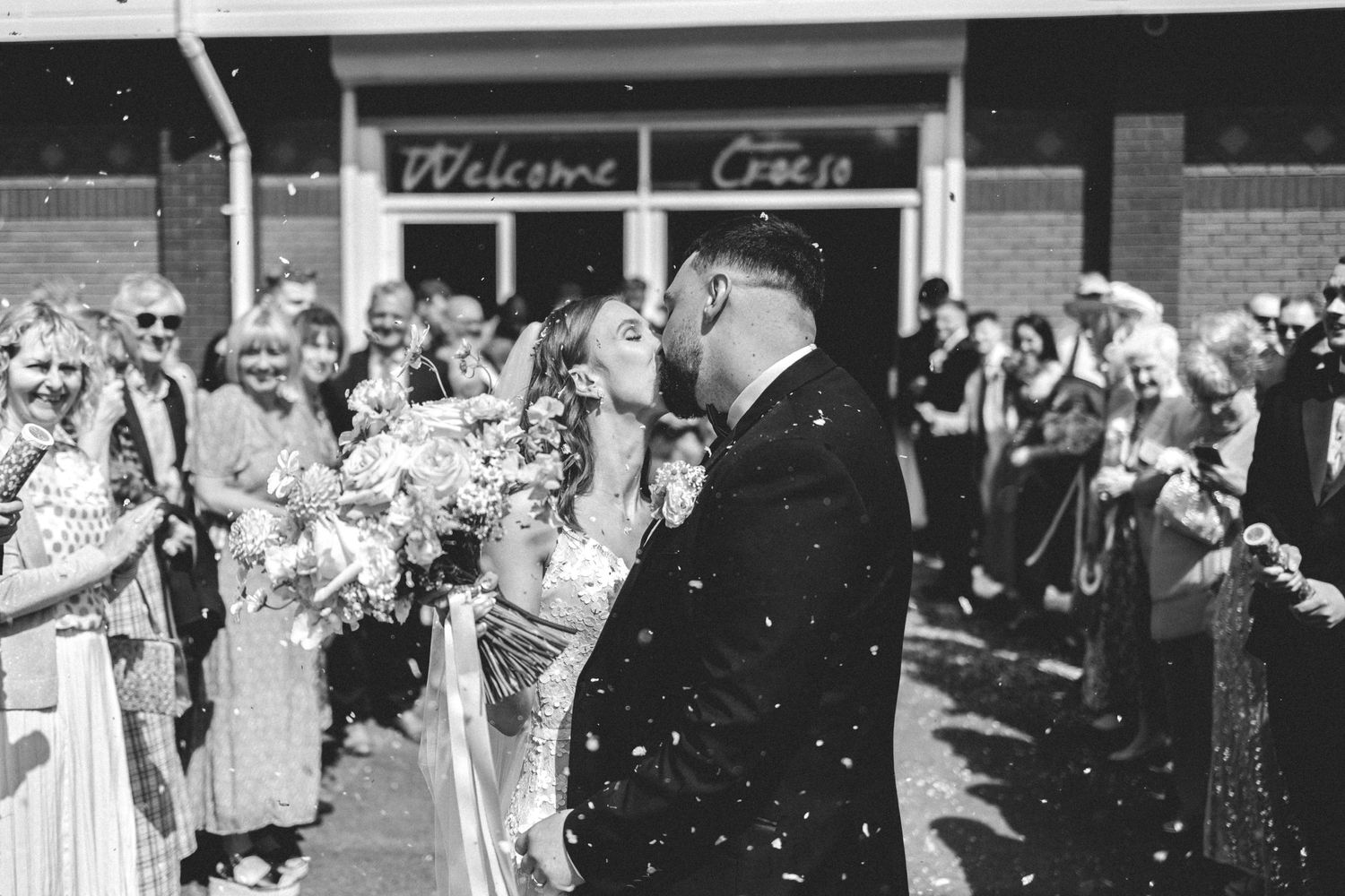 Black and white vintage photograph of a celebratory gathering outside a building.
