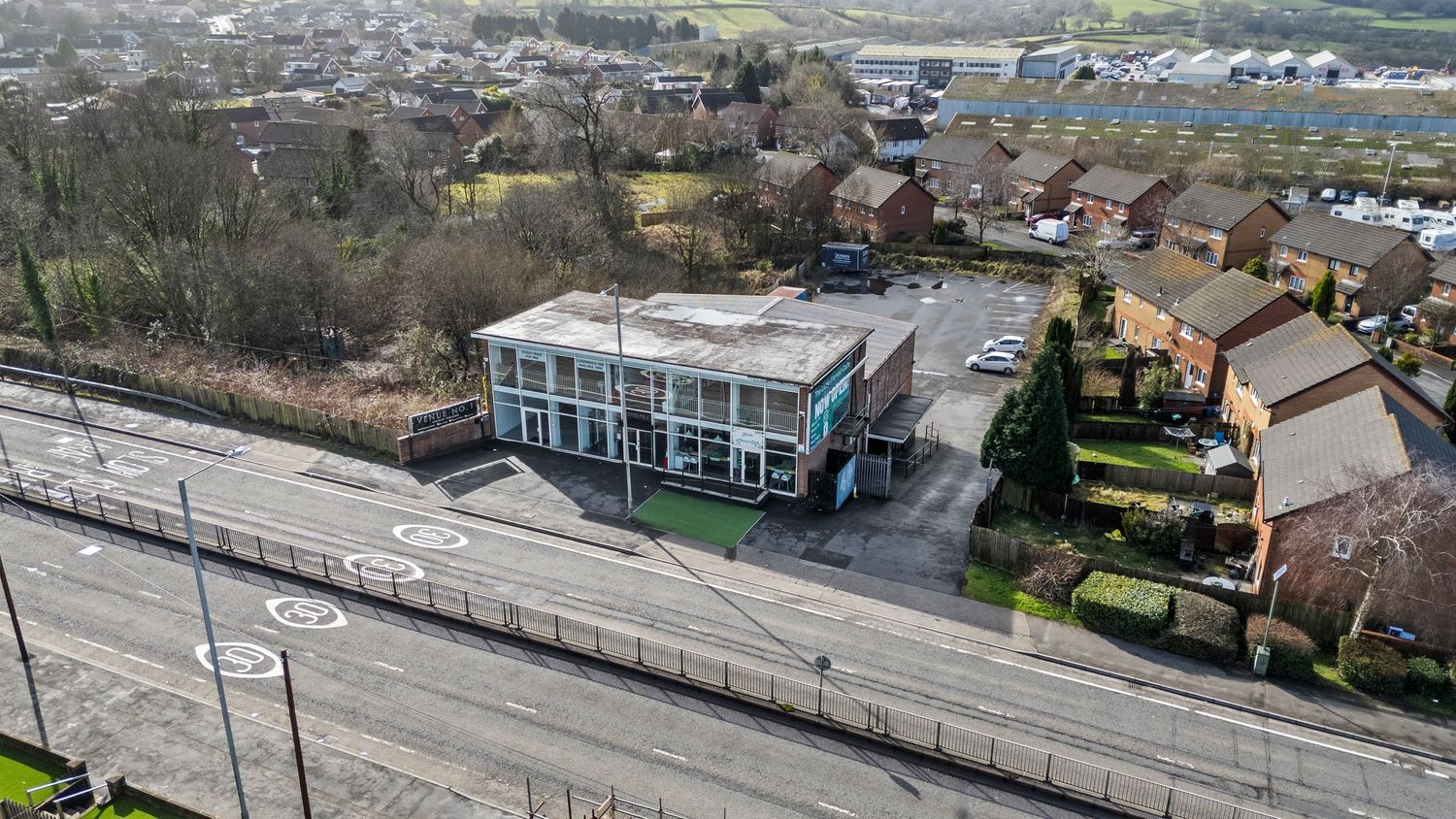 Modern commercial building alongside railway tracks in suburban setting. Venue 1, Swansea, South Wales.