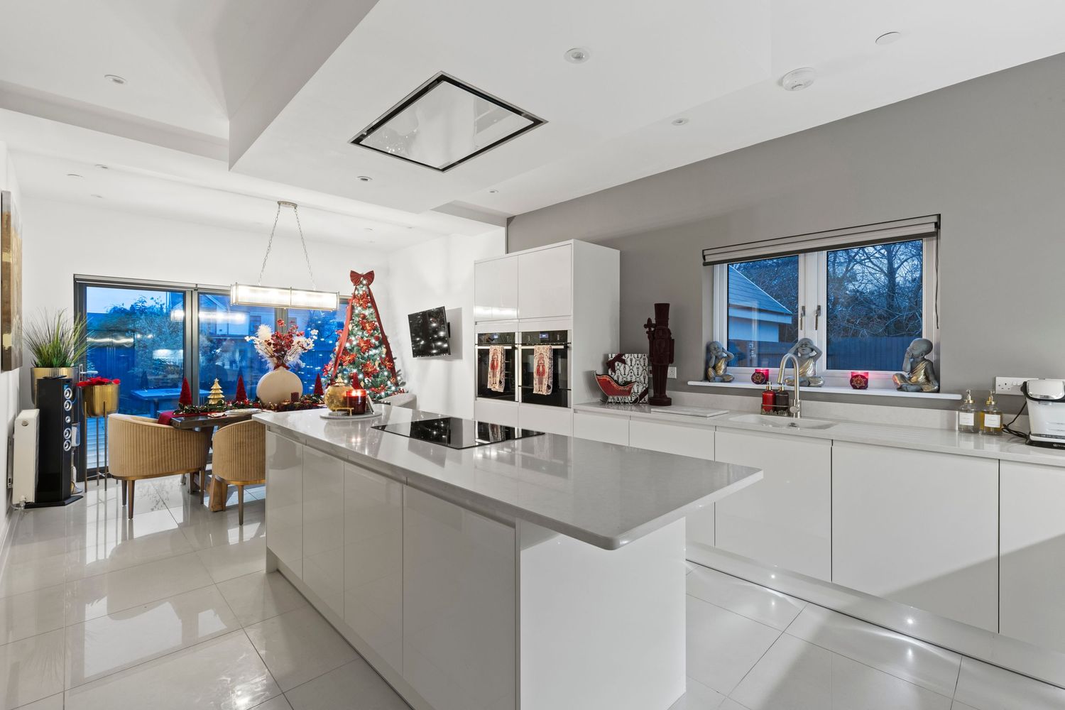 Sleek white modern kitchen with large island and minimalist design features.