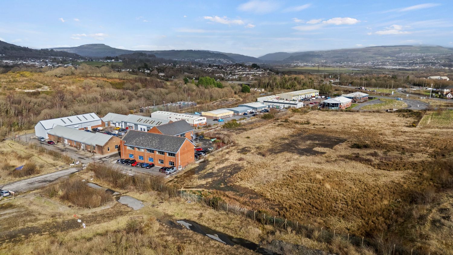 Panoramic view of industrial buildings and warehouses in a rural landscape.