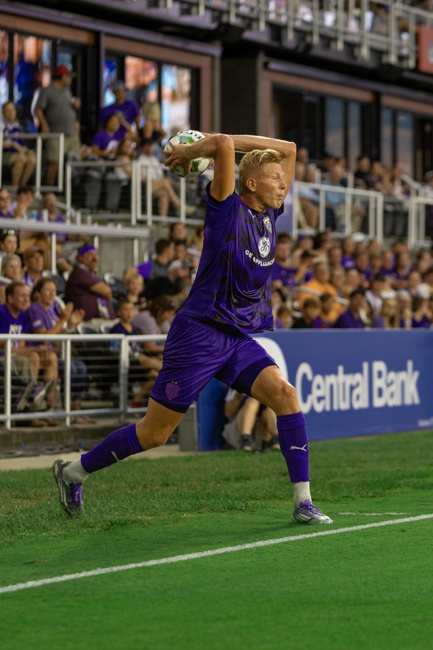 A sequence of action shots shows a soccer player in purple uniform diving and sliding on the field during a match.