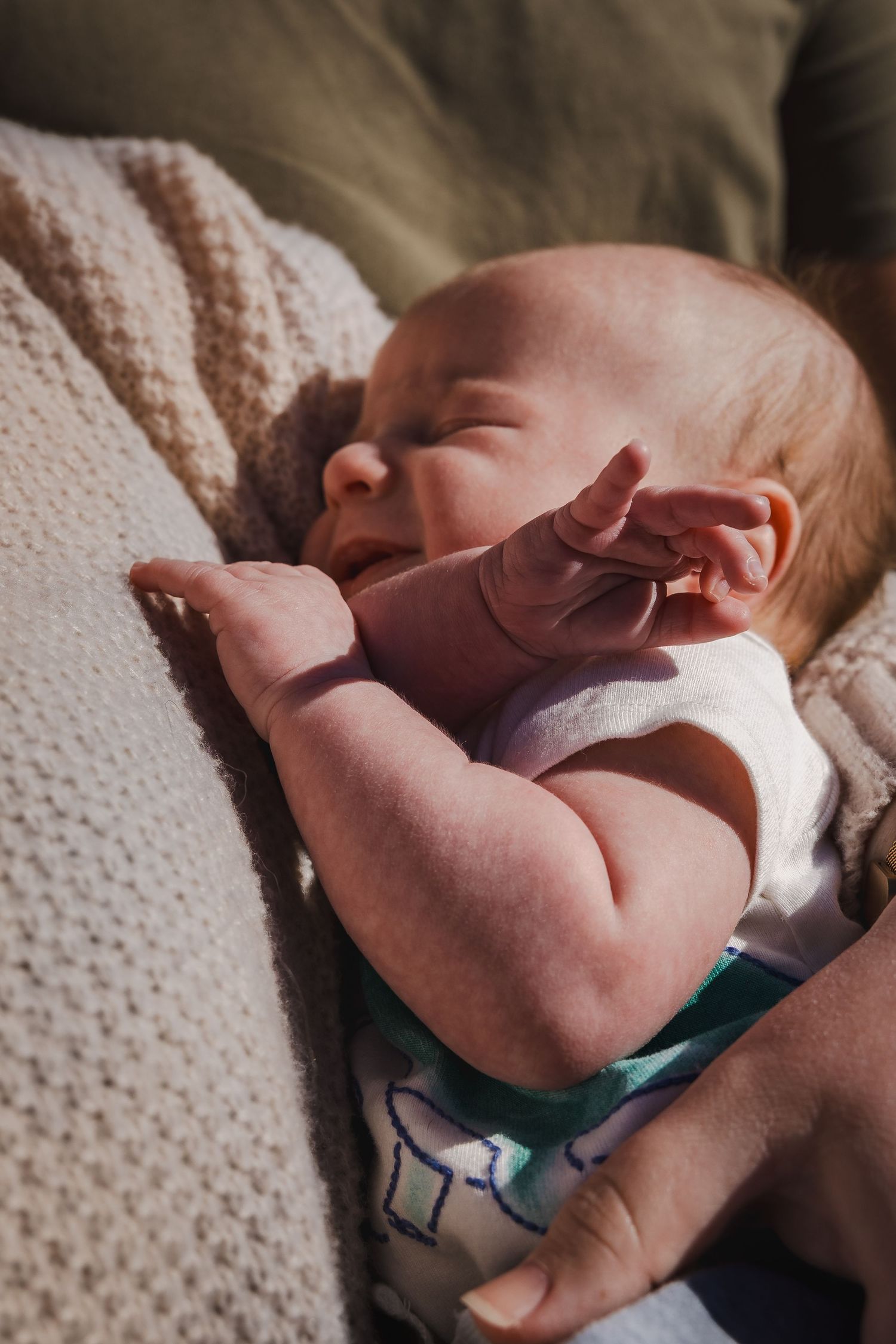 Sleeping newborn baby wrapped in a cozy knit blanket.