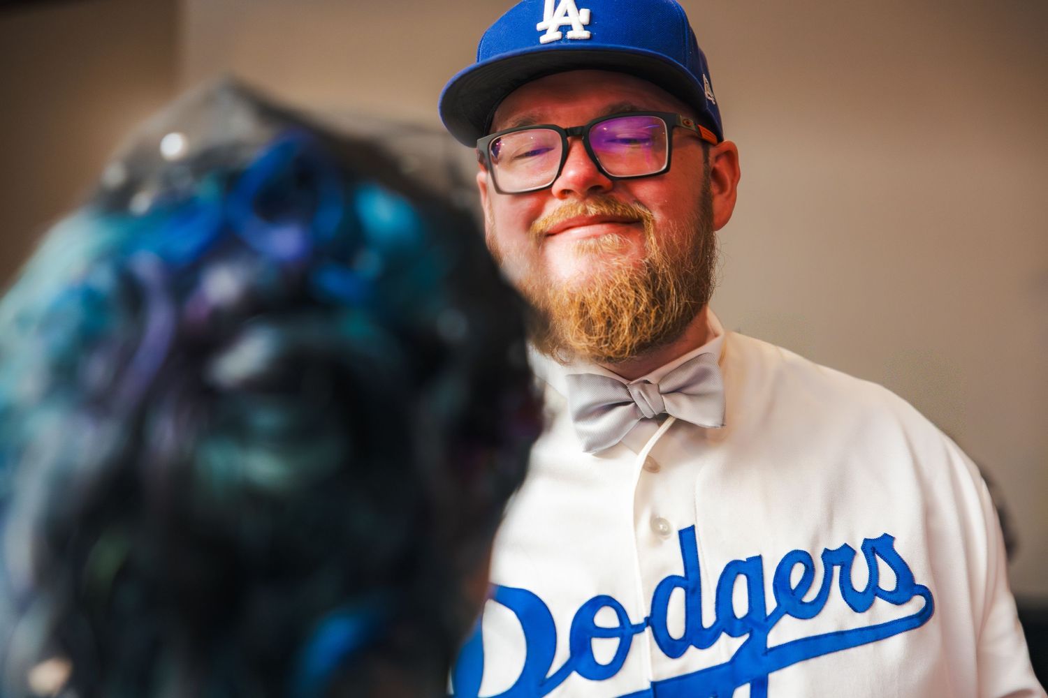 A group of baseball fans wearing LA Dodgers gear gather together at an event.