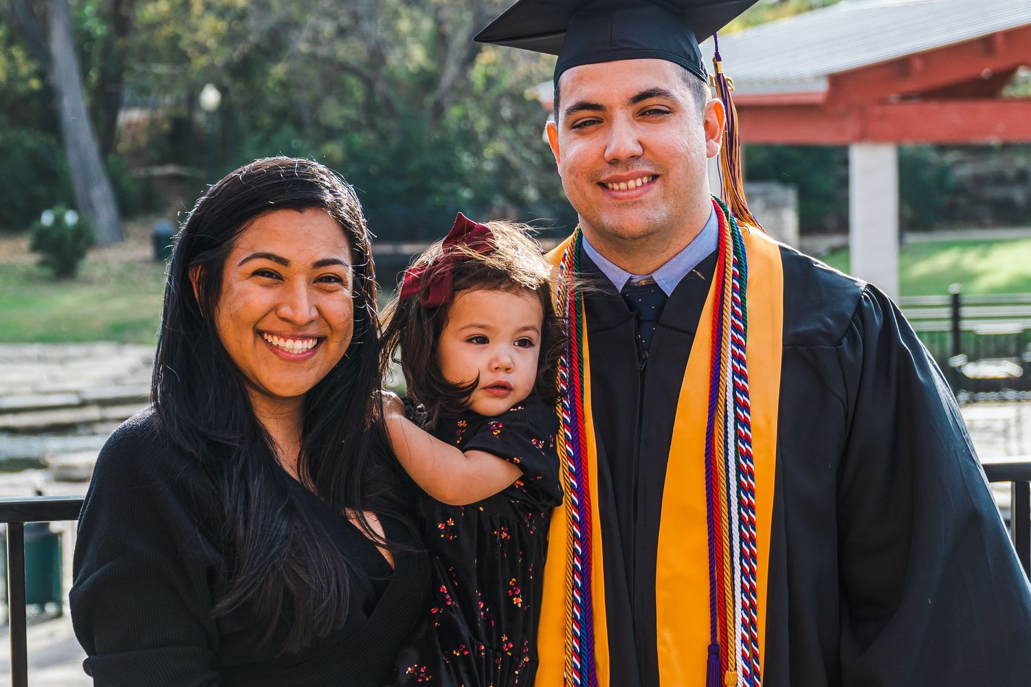 A collage of graduation photos showing graduates wearing caps and gowns with orange and blue stoles celebrating their achievement.