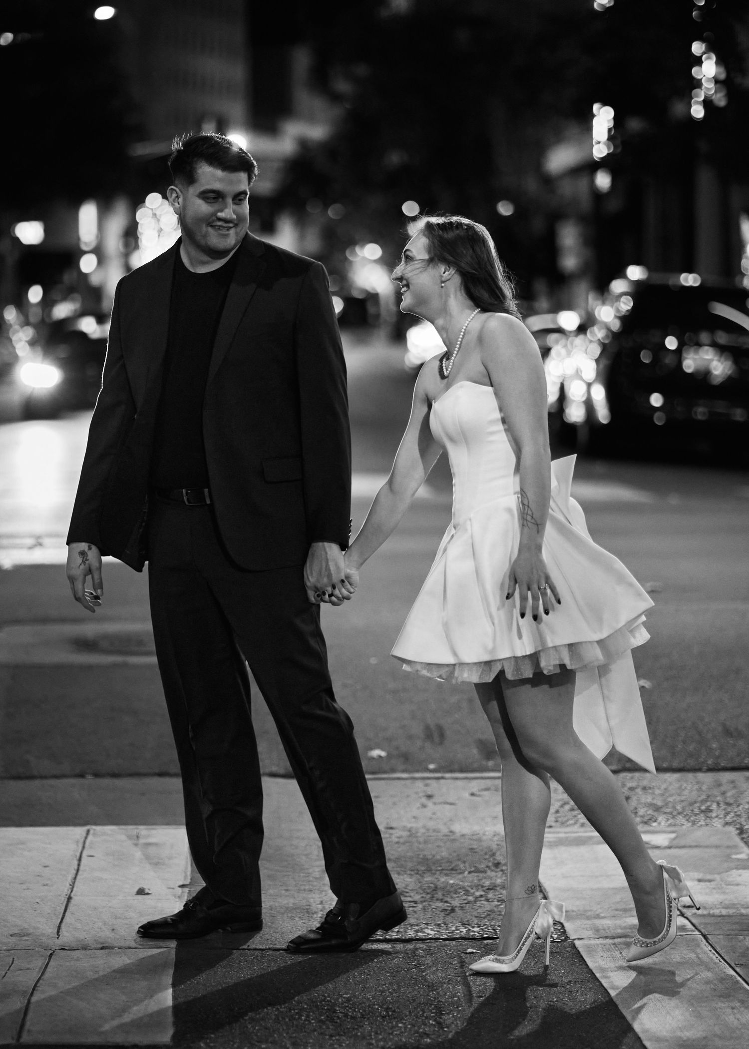 Couple dancing at night on city street in black and white photo sequence.
