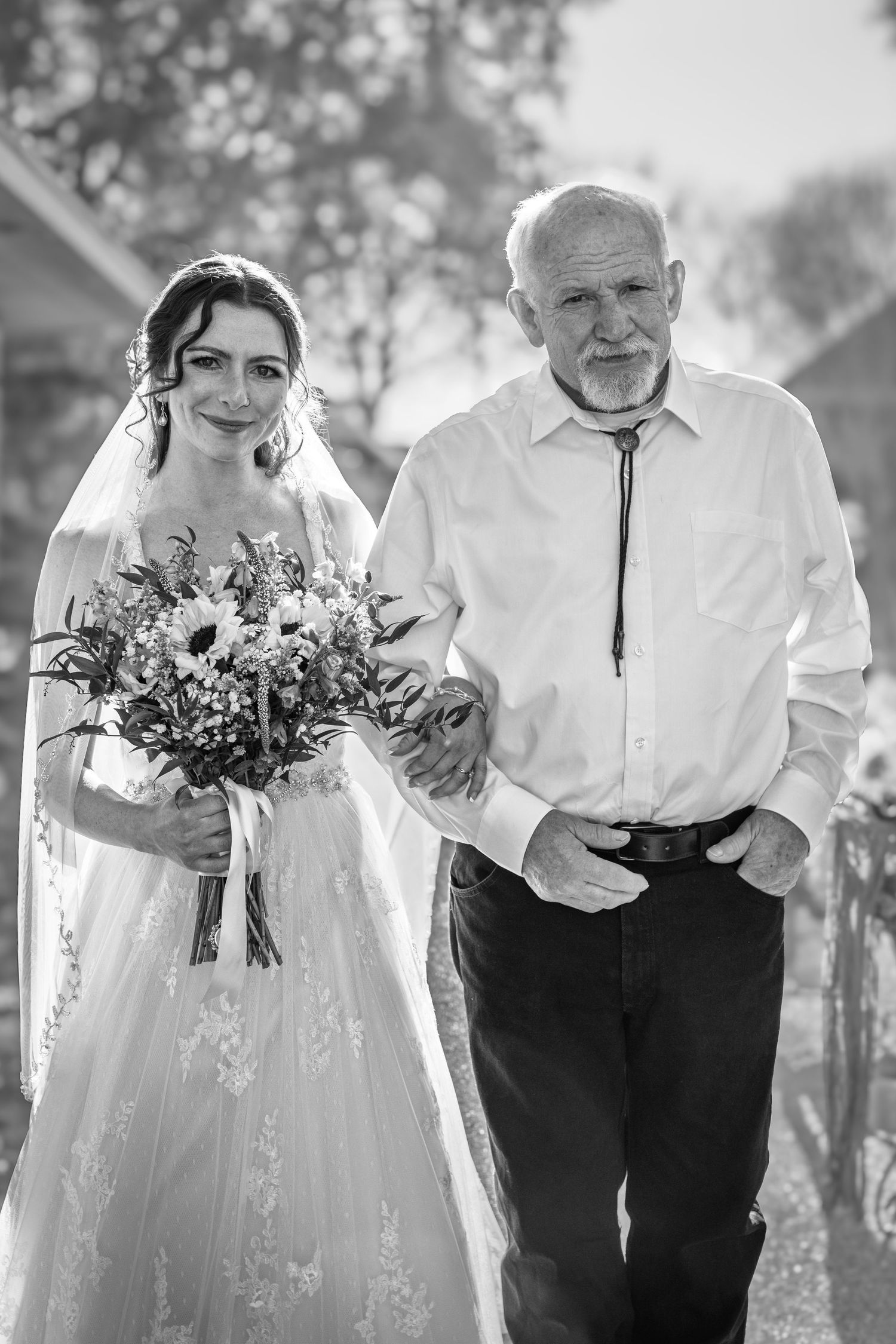 Black and white photo series showing a bride and grandfather in wedding attire walking and laughing together outdoors.