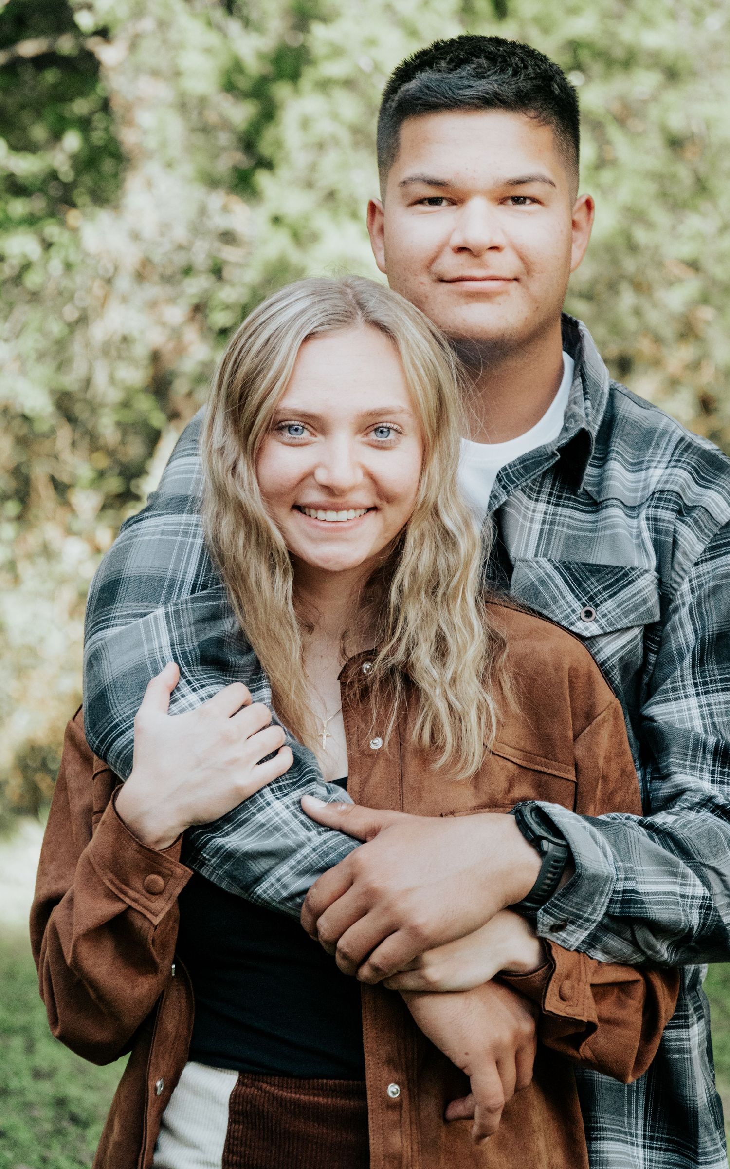 Couple in casual fall attire sharing a sweet moment outdoors.