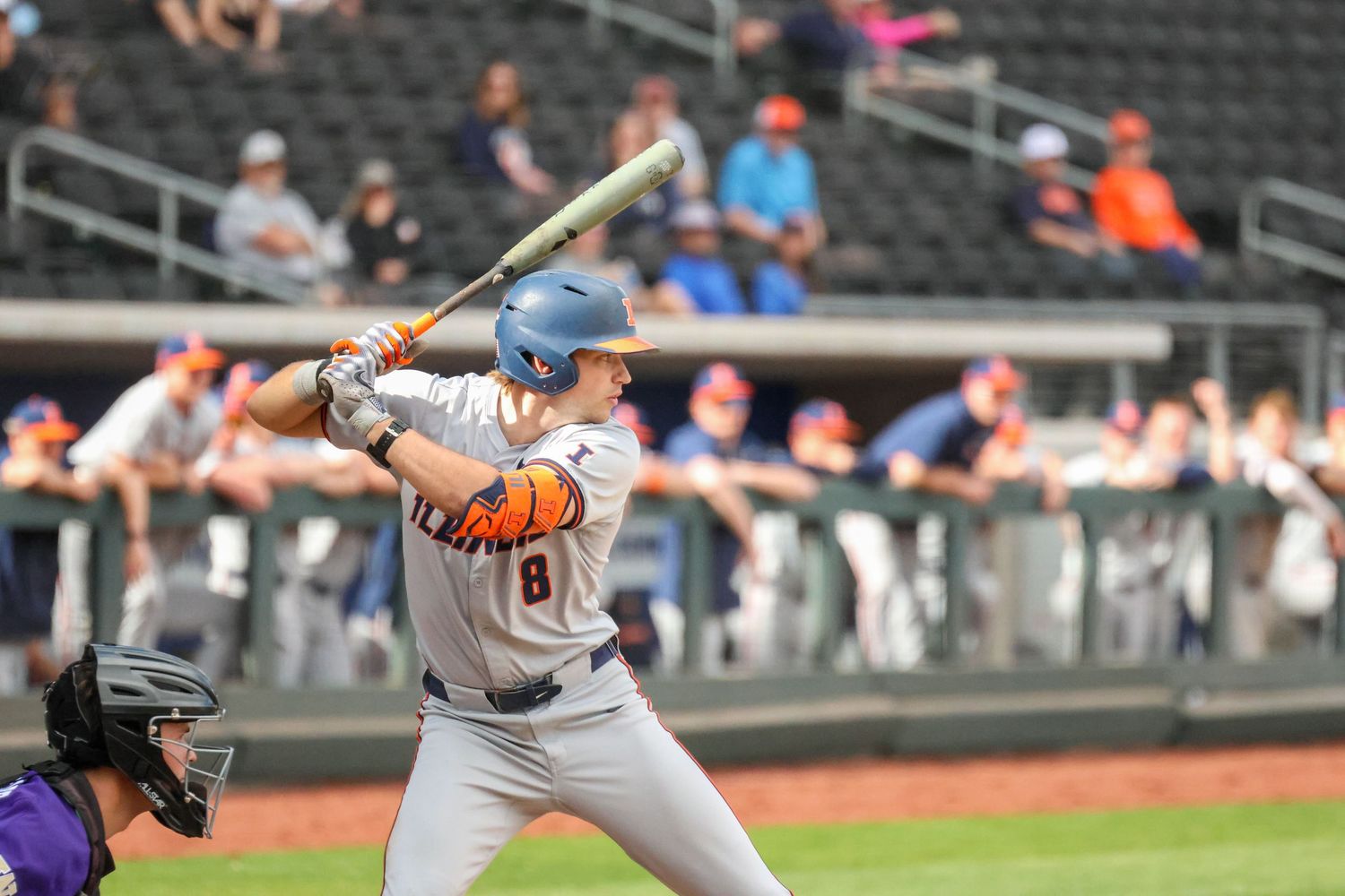 Professional baseball batter in gray uniform follows through on swing at home plate during game.