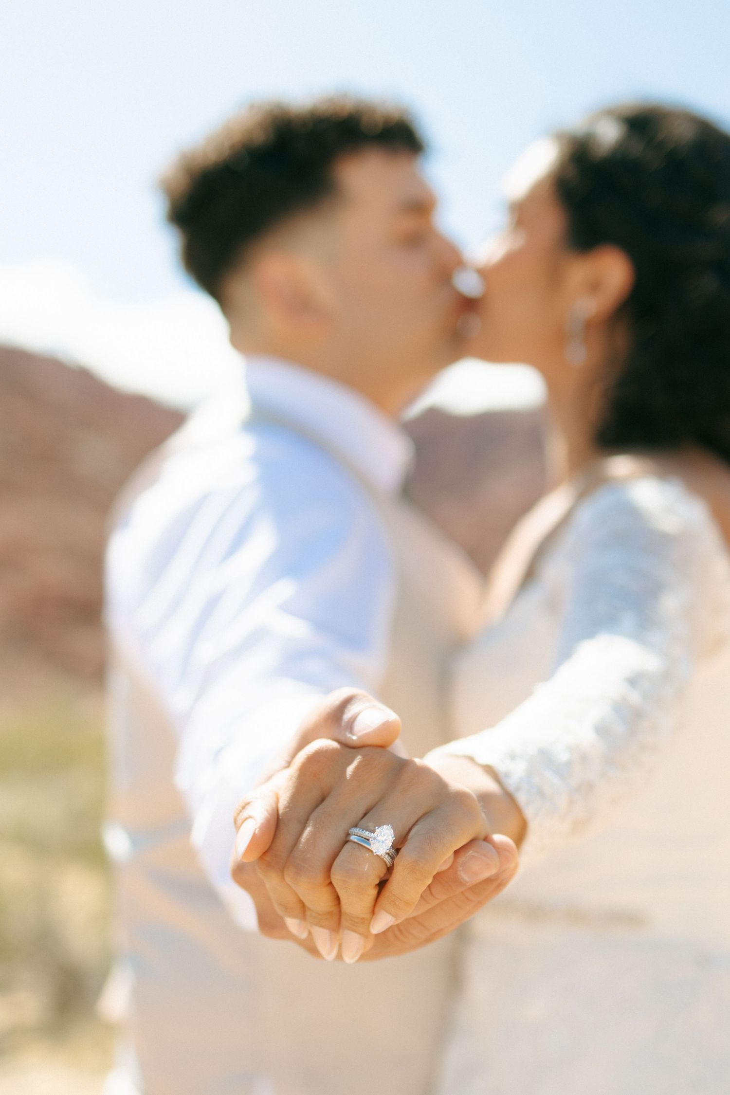 Close-up shots of a couple holding hands showing their wedding rings in an outdoor desert setting.