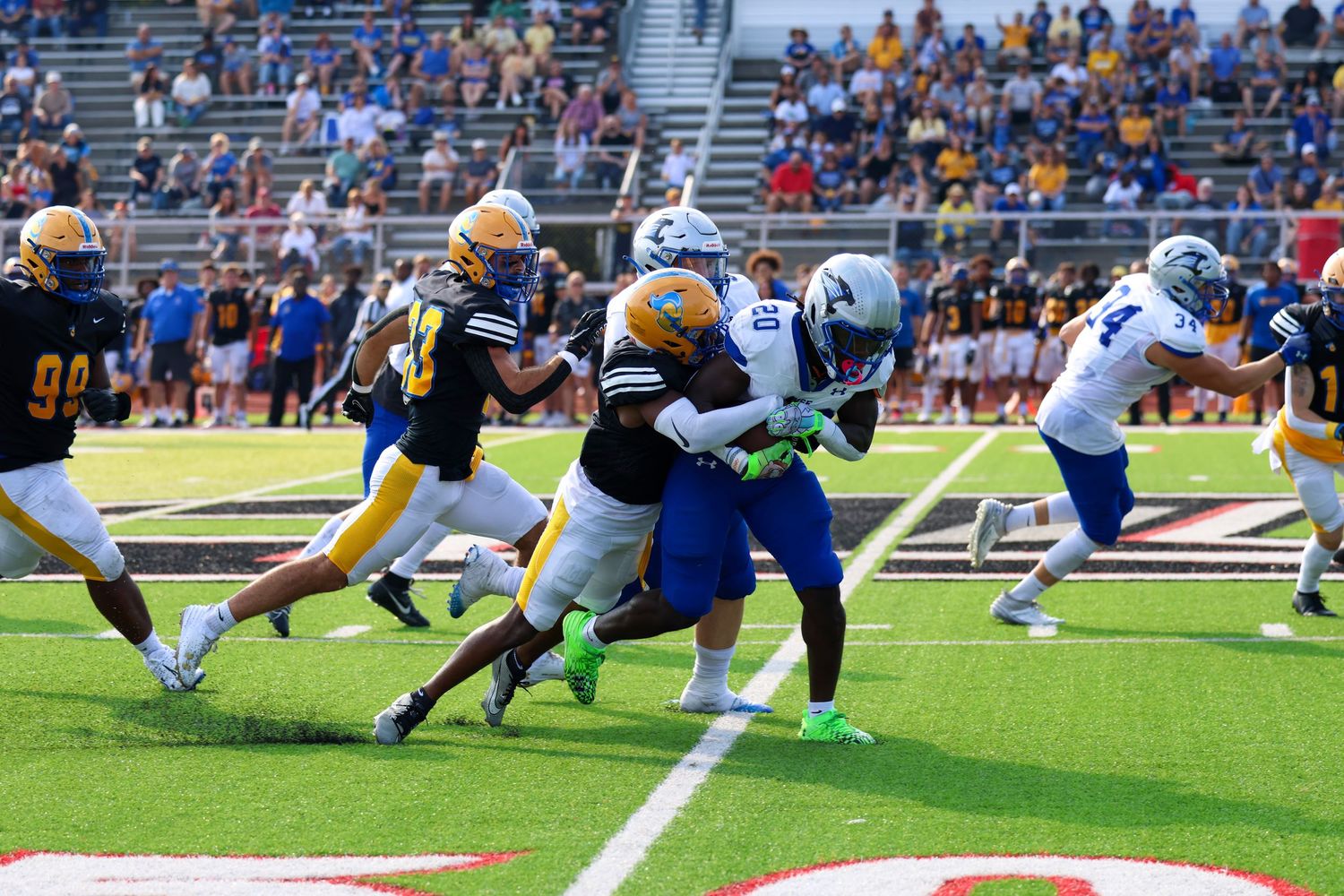 College football players collide during an intense defensive play on the field during a game.
