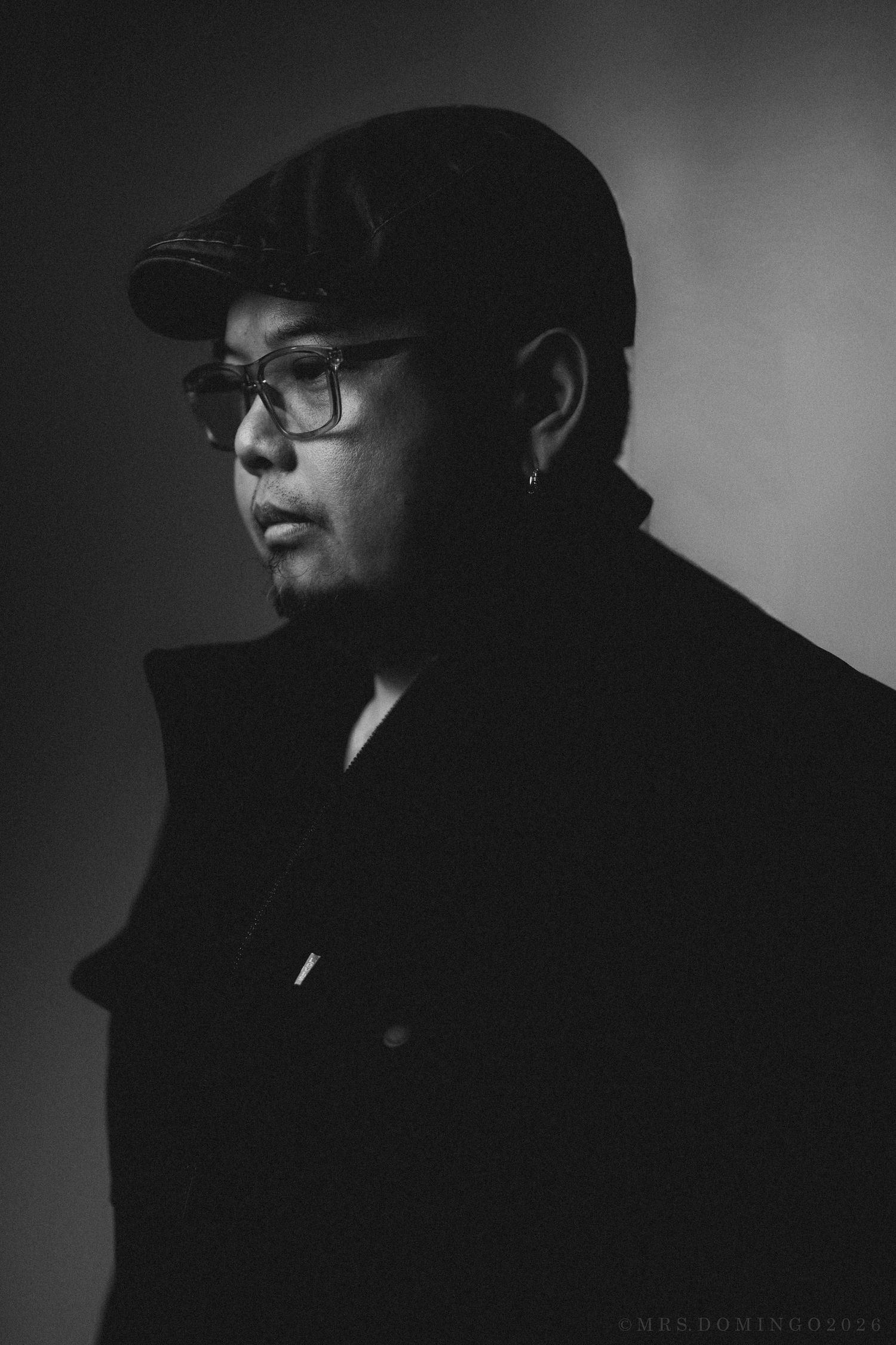 Dramatic black and white silhouette portrait series showing a figure wearing glasses and a hat in moody lighting.