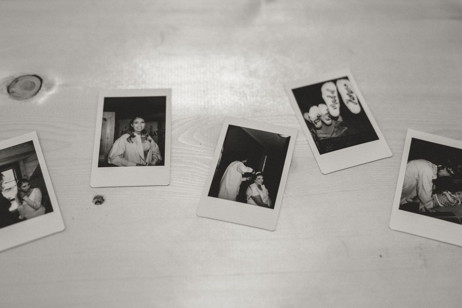 A collection of vintage black and white polaroid photographs arranged on a white surface.