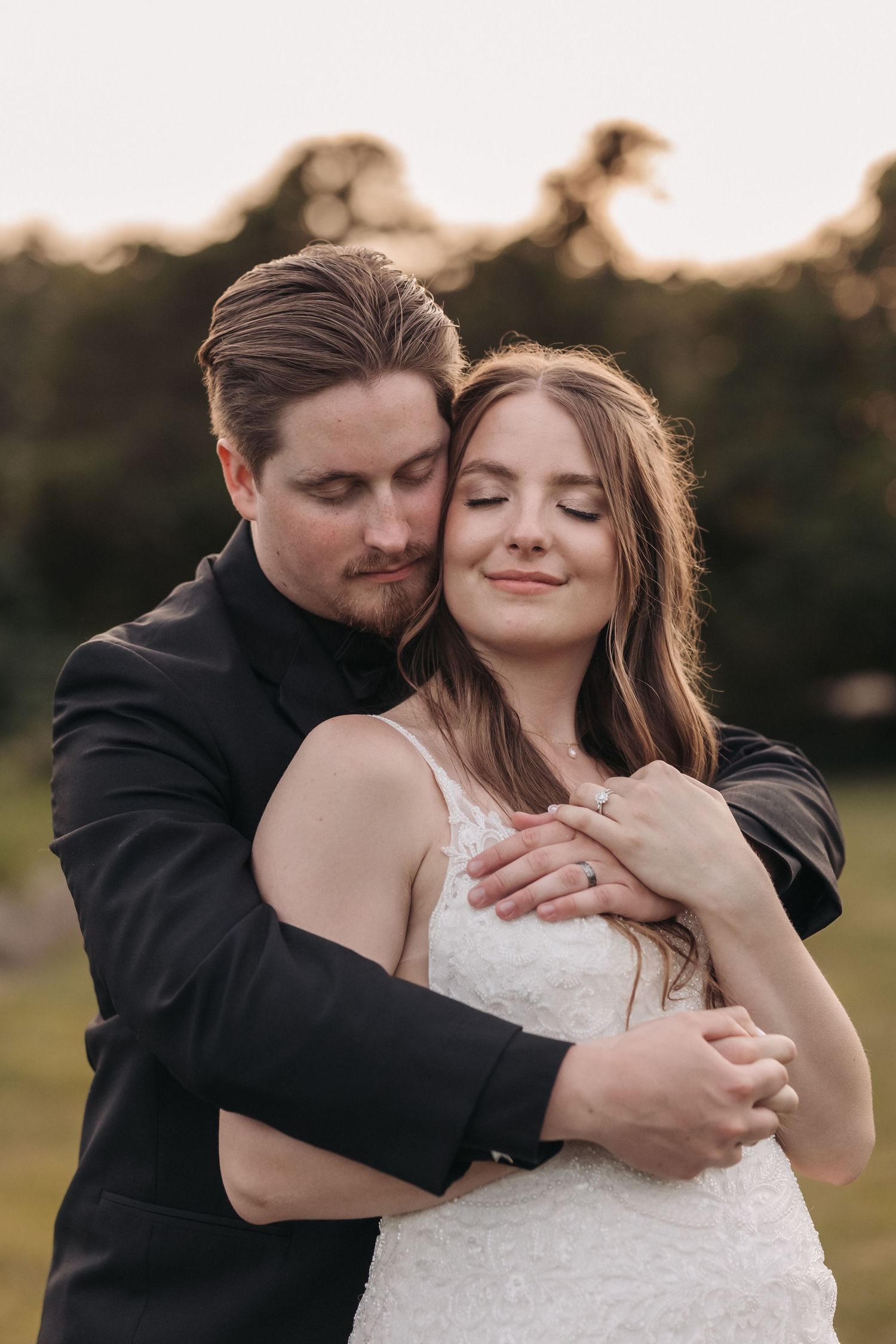 A romantic embrace between newlyweds during golden hour outdoors.
