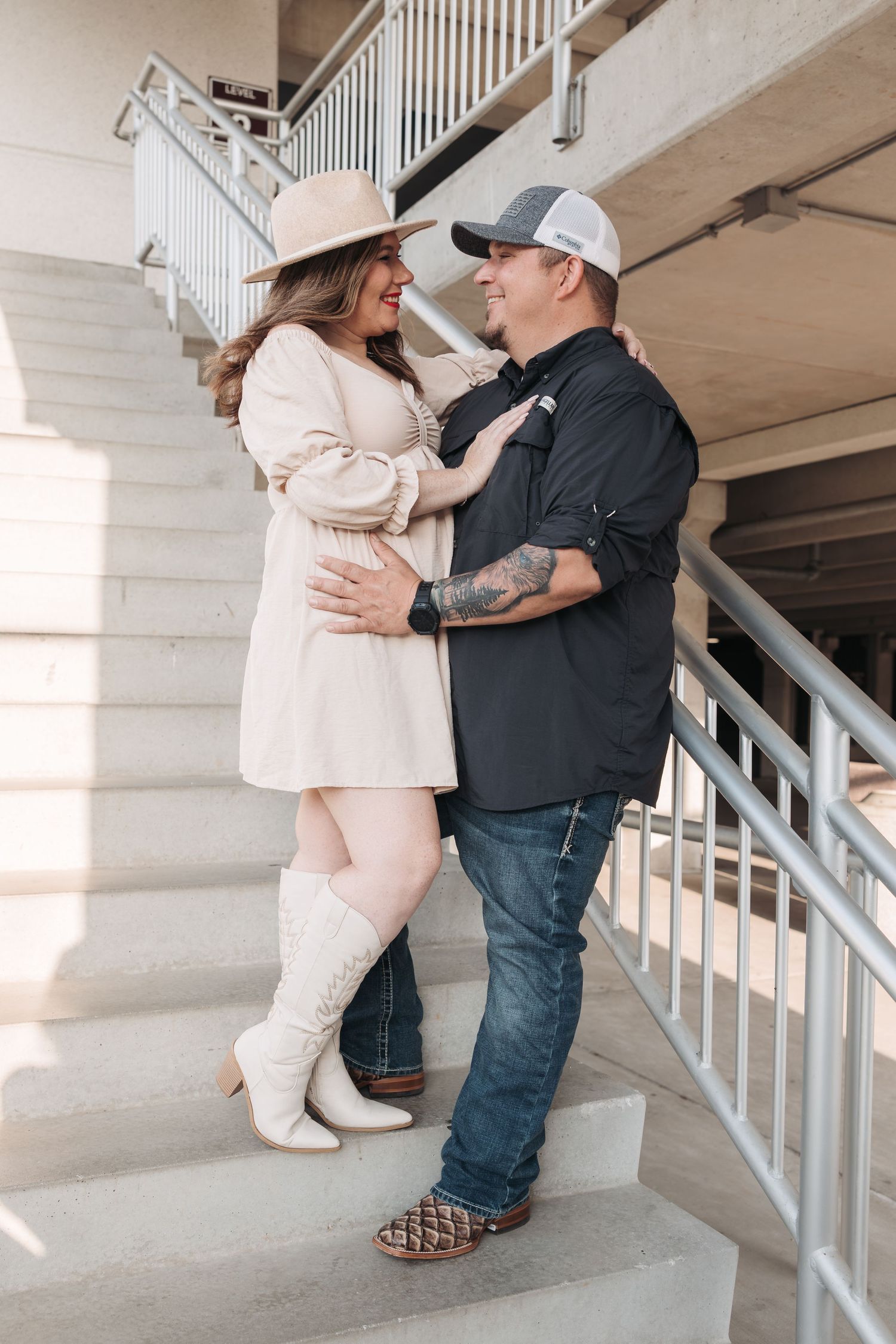 Couple in casual winter attire sharing an intimate moment on white stairs.