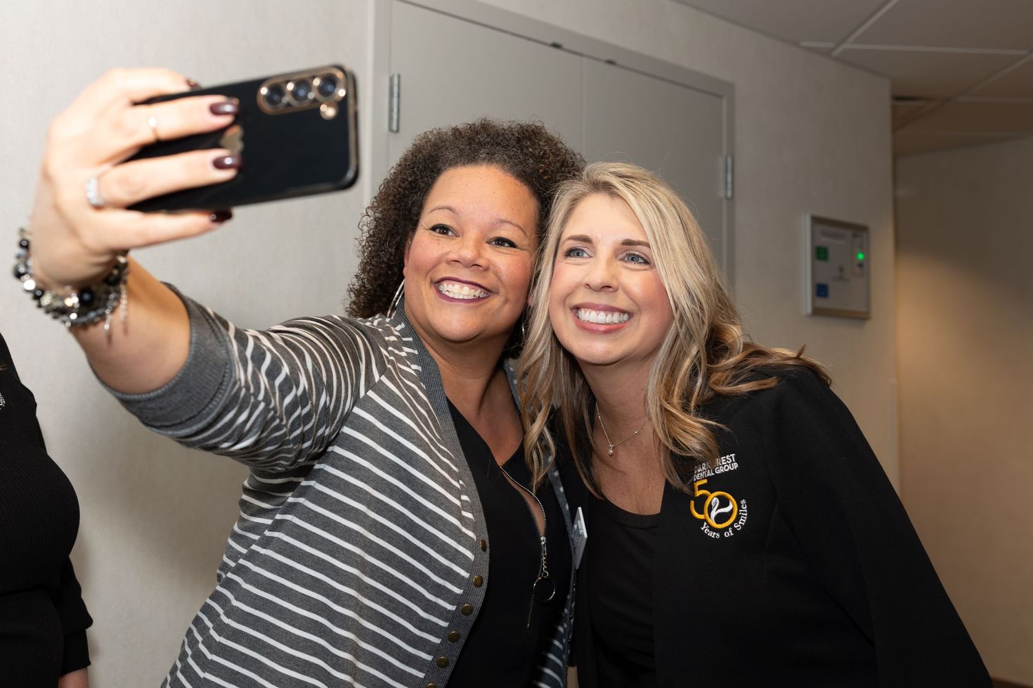 Two colleagues taking a selfie together at an office event.
