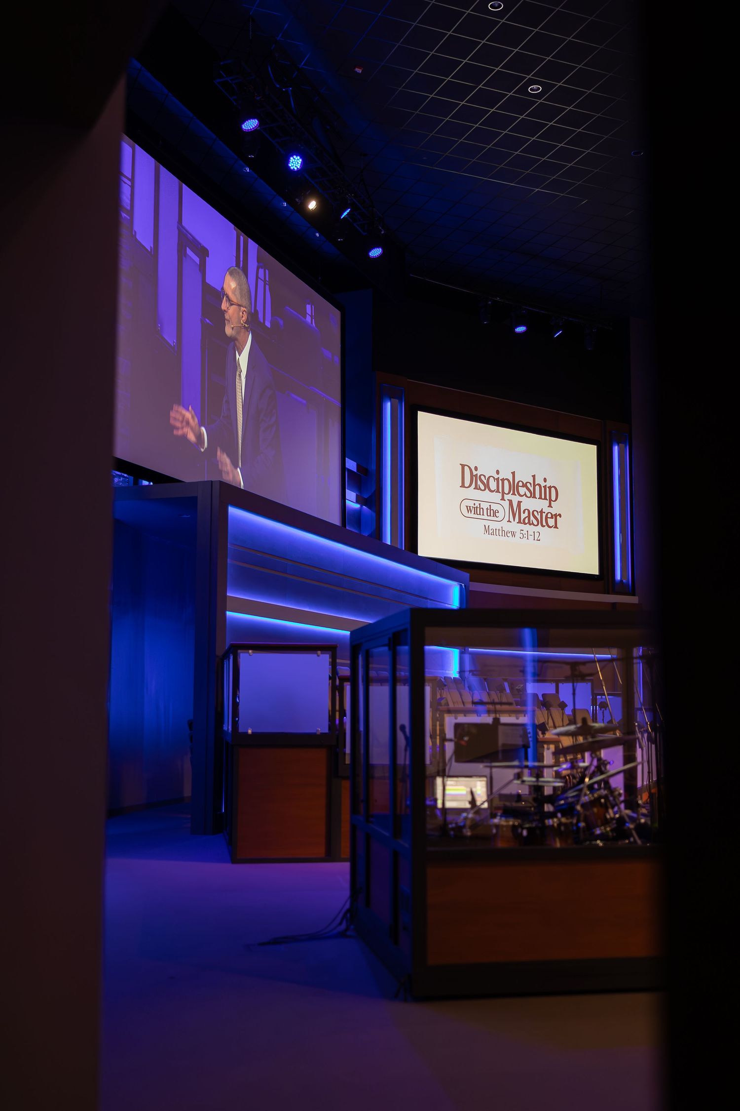 Dark auditorium with illuminated presentation screen and 'Discipleship Class' sign.