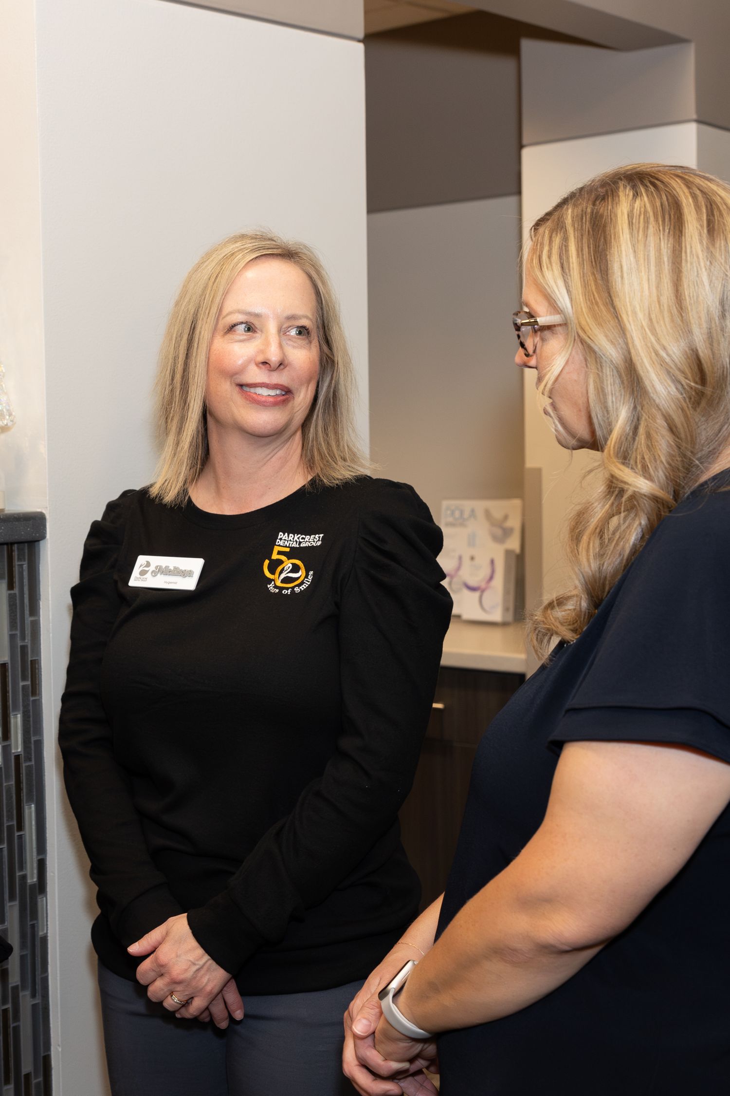Two staff members having a friendly conversation at office celebration.