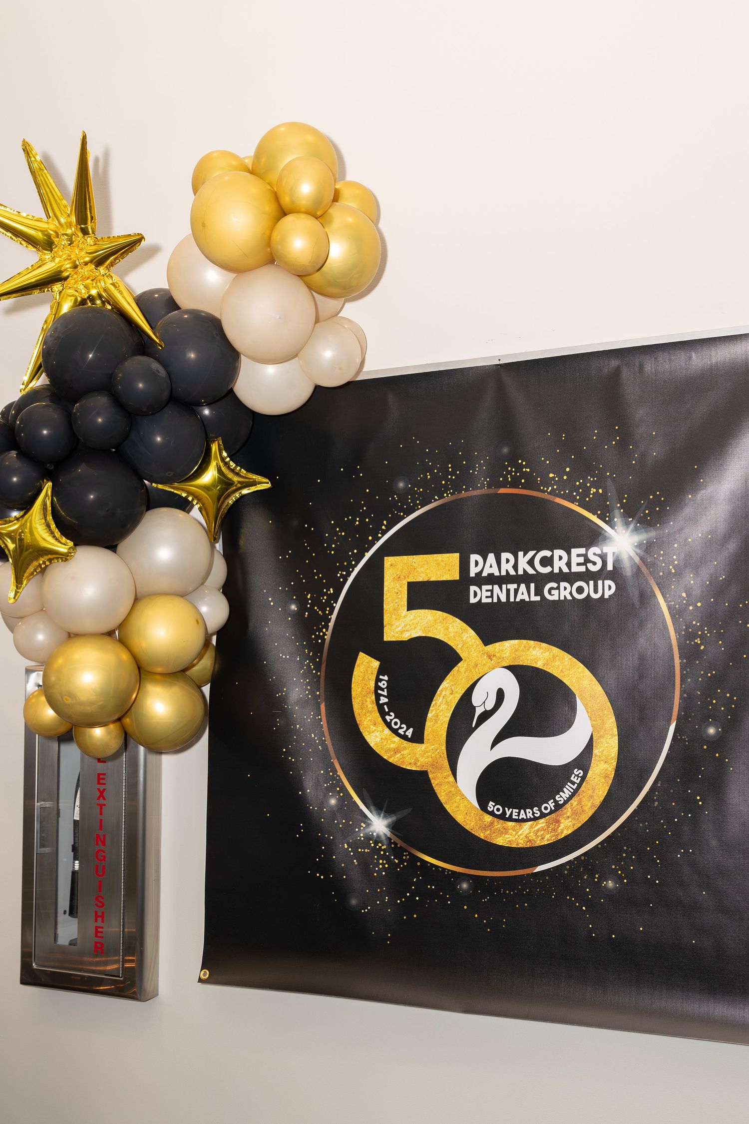 Parkcrest Dental Group 50th anniversary logo display with gold and black balloon arch.