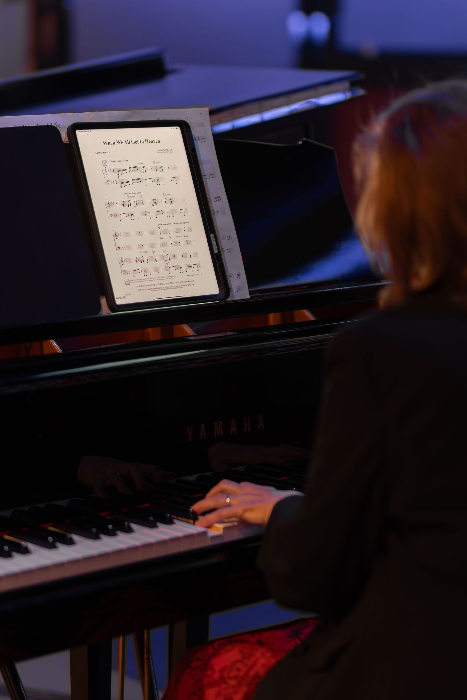 Sheet music displayed on piano stand during church performance.