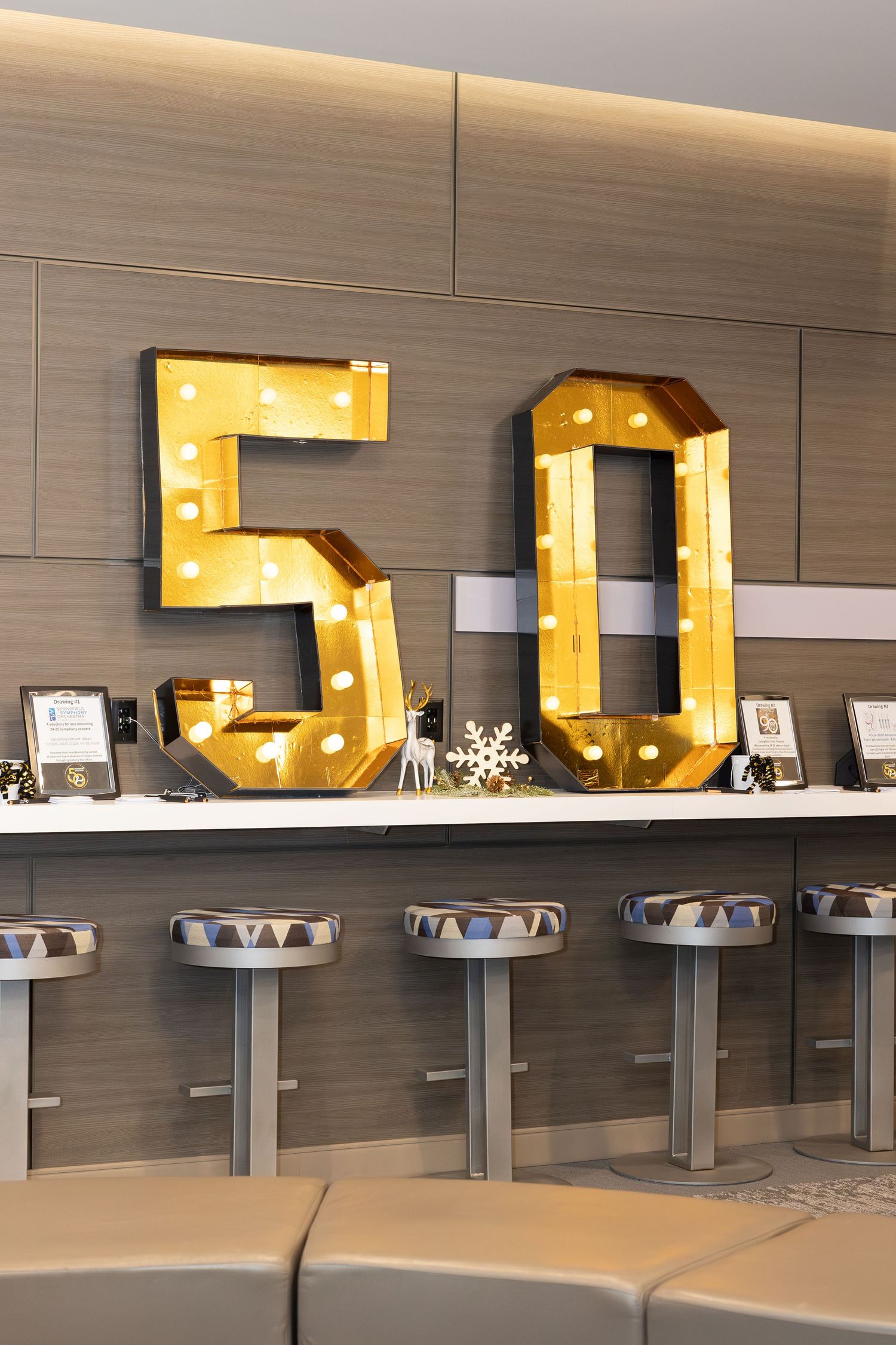Large illuminated number '50' marquee letters displayed on a shelf with decorative items.