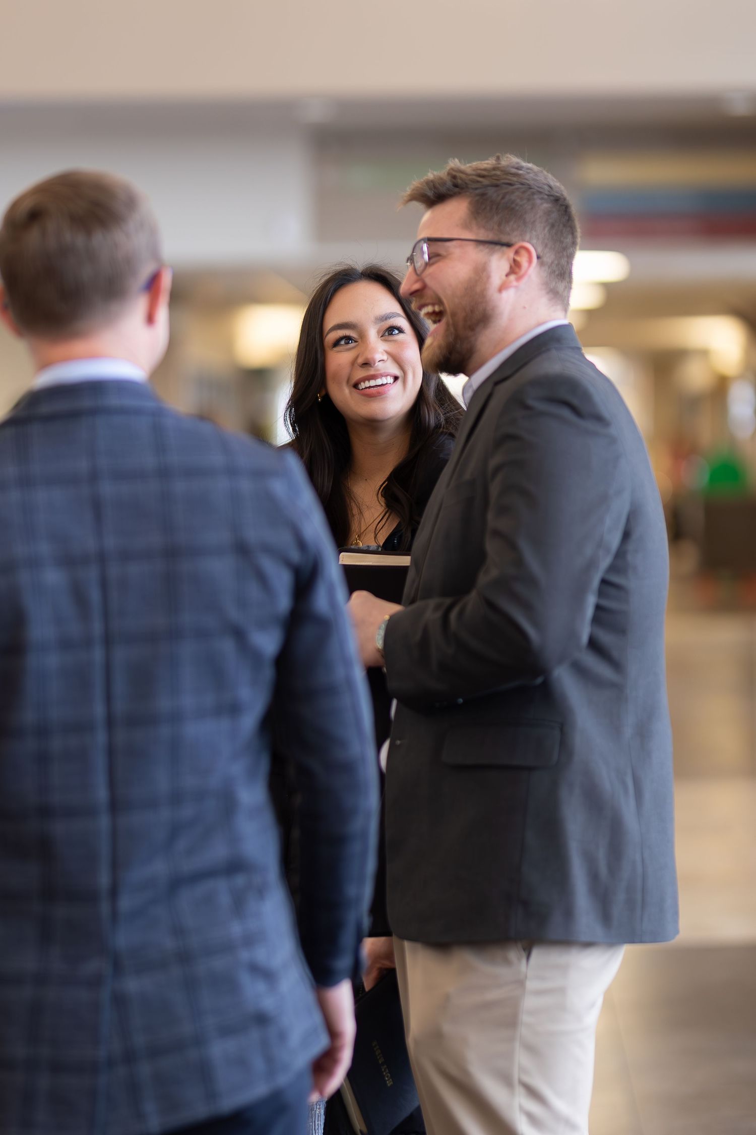 Small group engaged in casual conversation in a church hallway.
