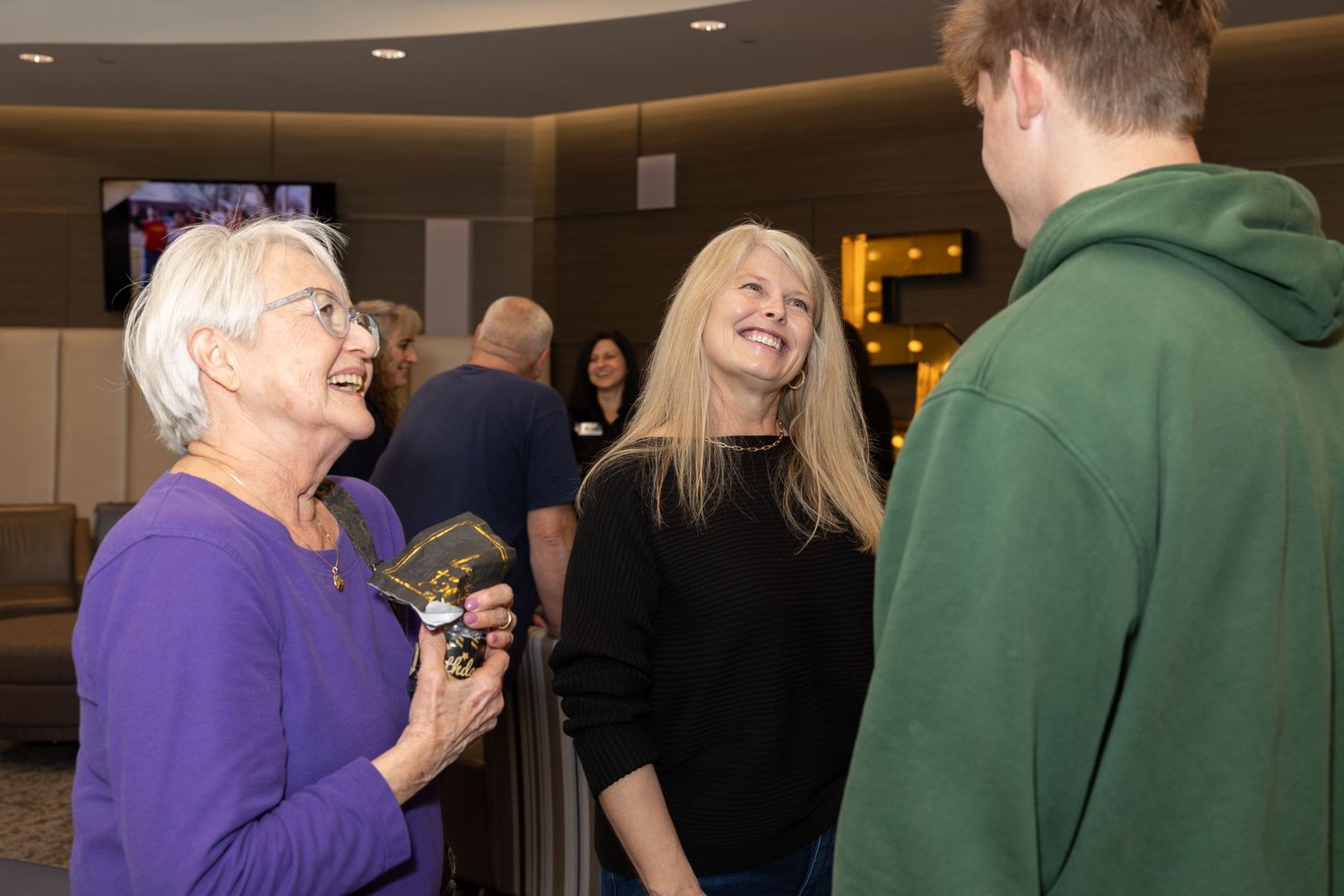 Small group having an animated conversation at an indoor event.