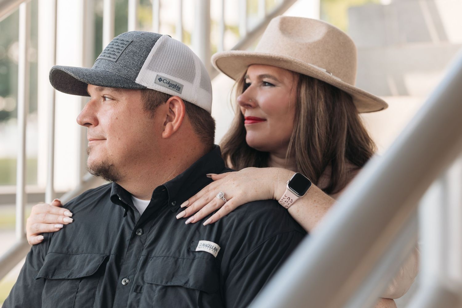 A couple in western-style clothing sitting together on outdoor steps.