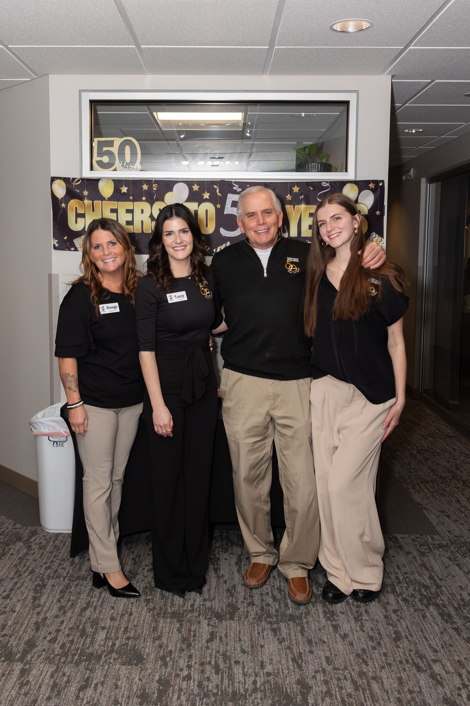 Group photo of staff members in coordinated attire at 50th anniversary celebration.