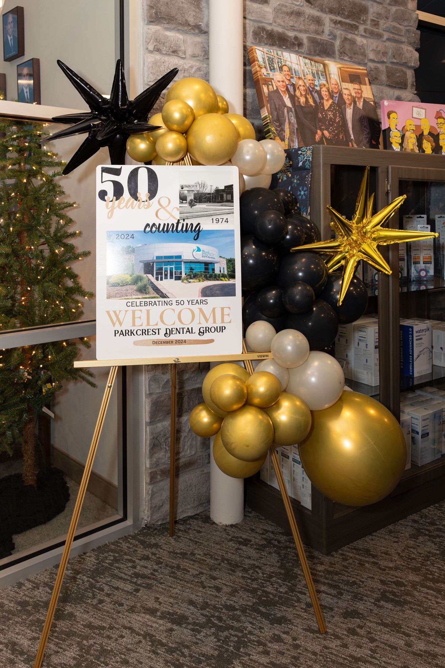 50th anniversary celebration display with gold and black balloons and decorative stars.
