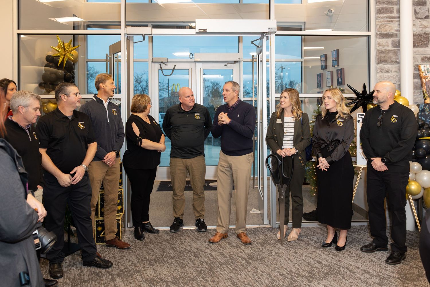 Business team members in professional attire stand together during a corporate gathering.