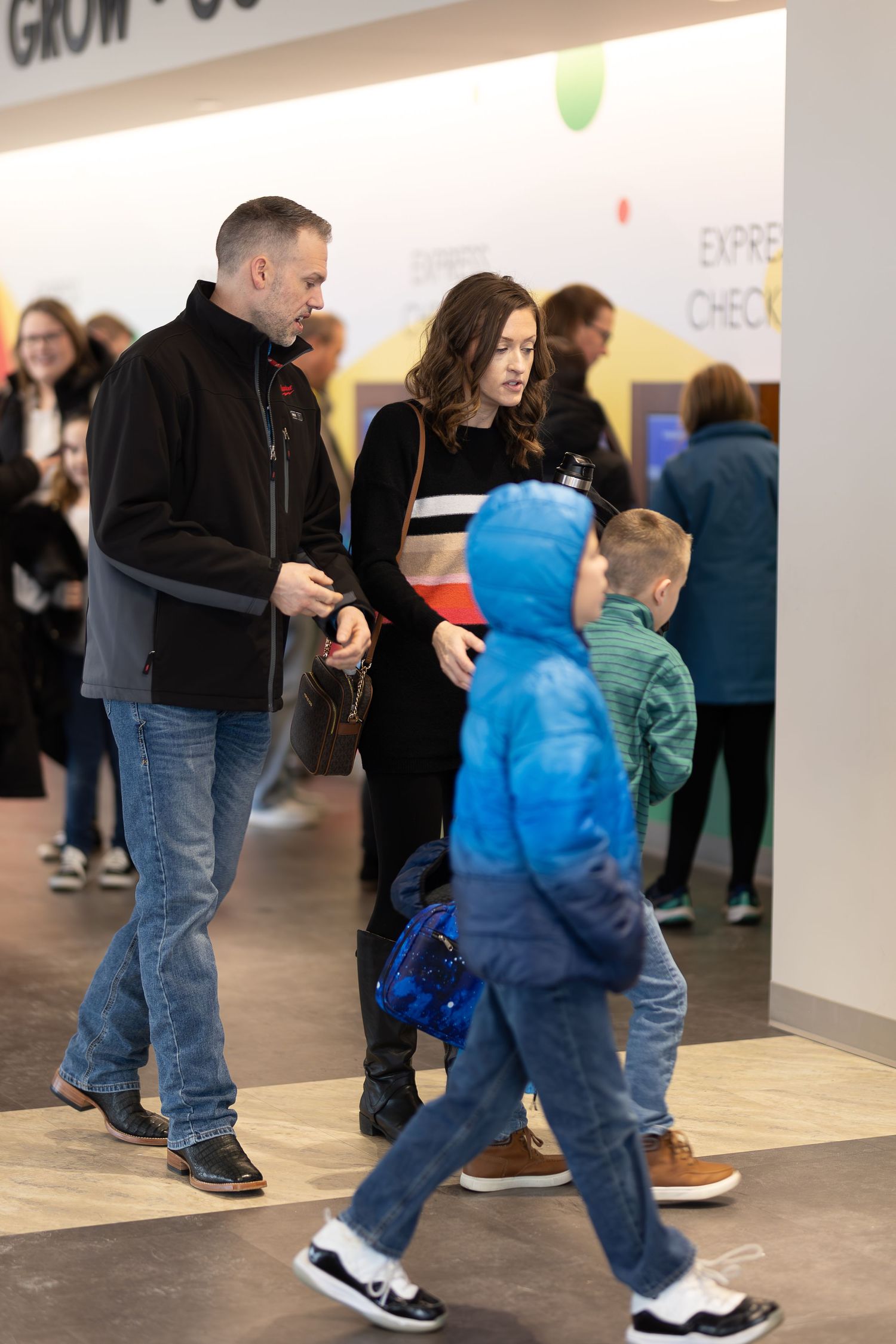 Small group walking through modern building hallway during event or gathering.