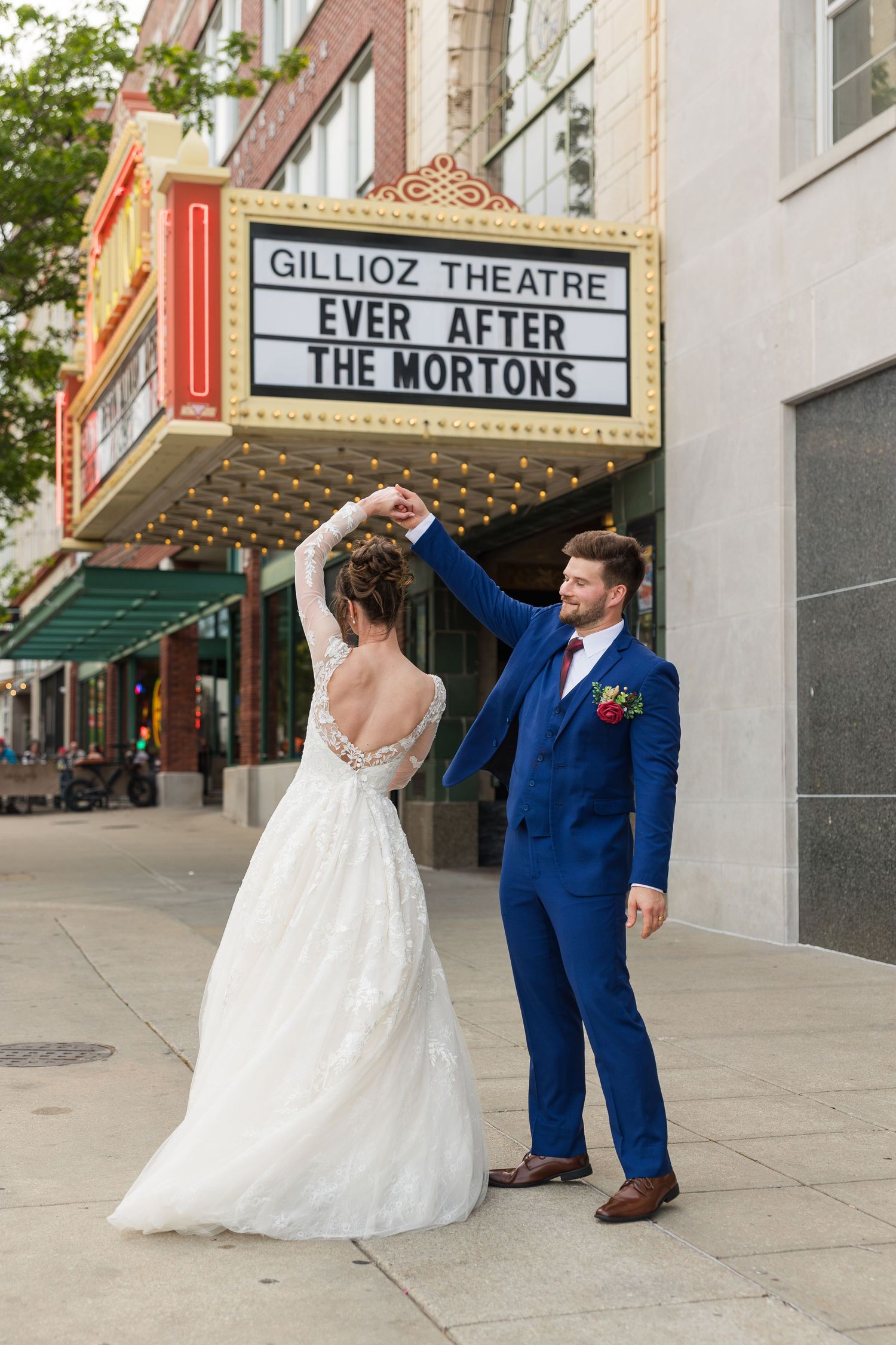 Bride and groom dance in front of the Gillioz Theatre marquee reading Ever After The Mortons.