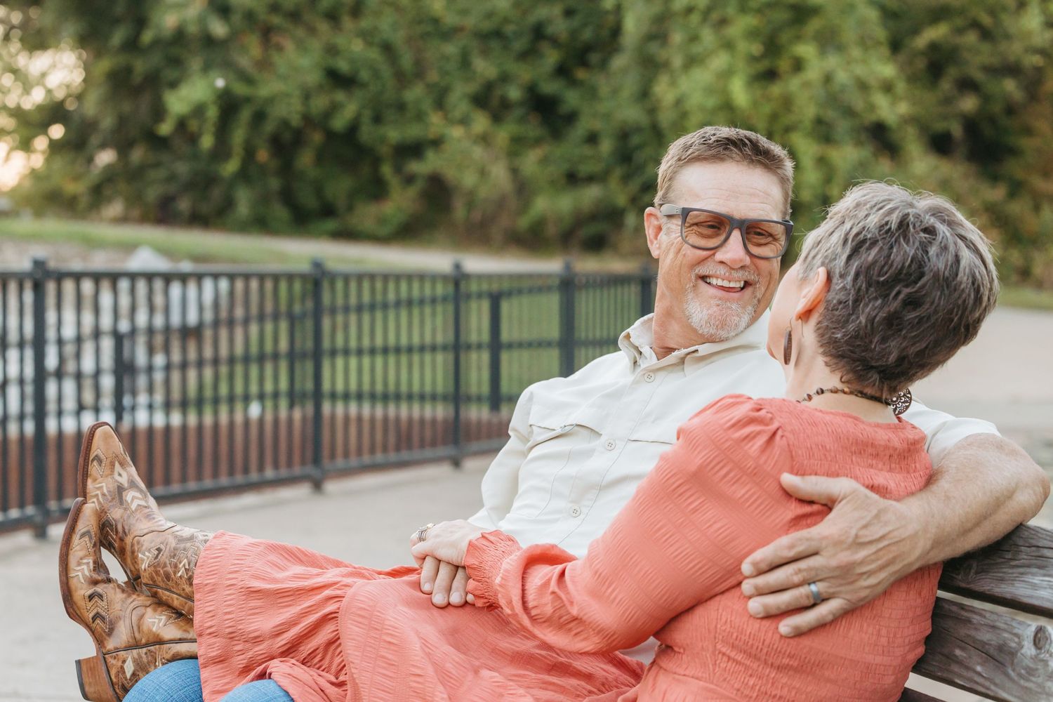Happy couple relaxing on outdoor bench sharing tender moment together.
