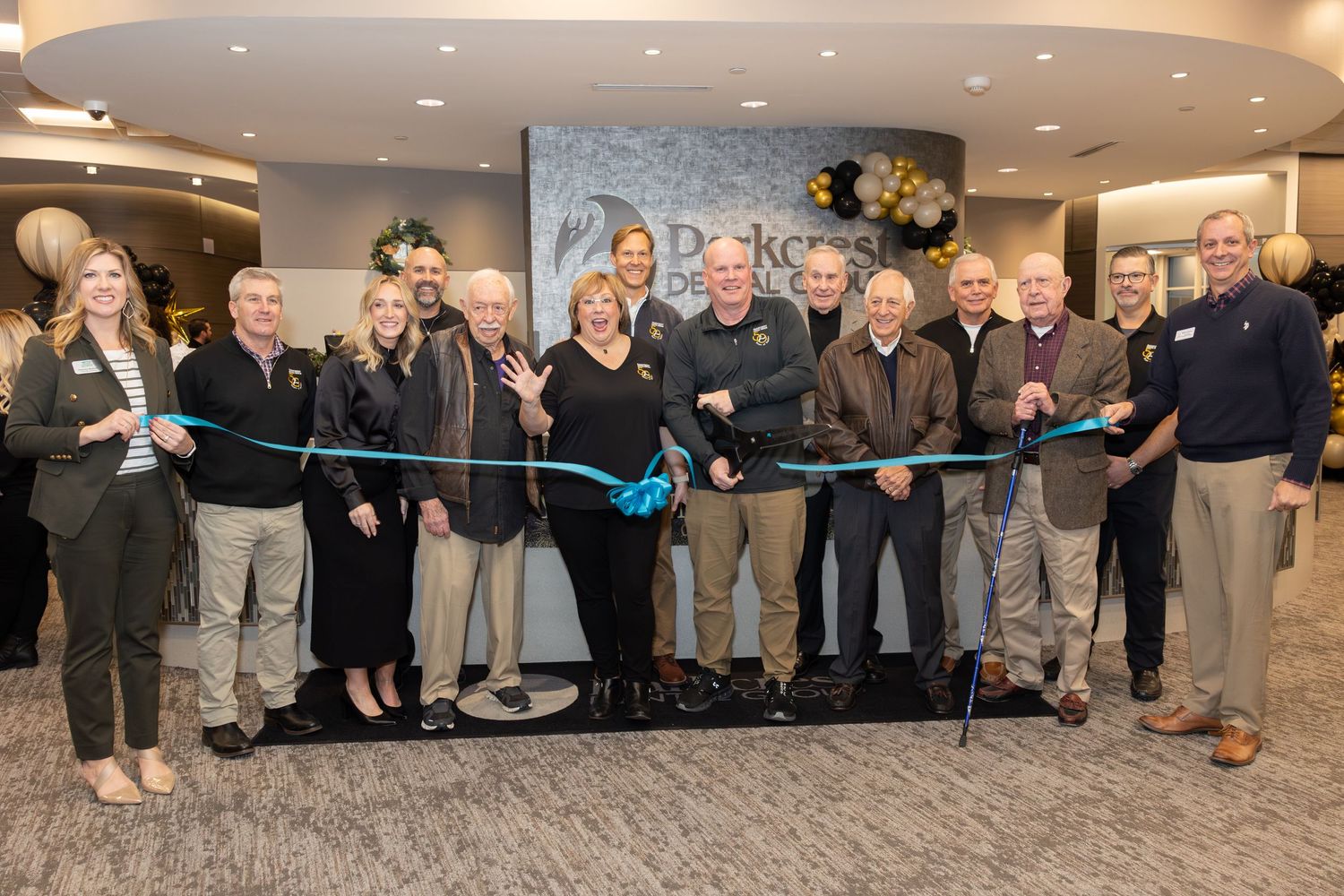 A ribbon cutting ceremony with a large group gathered indoors for a formal event opening.
